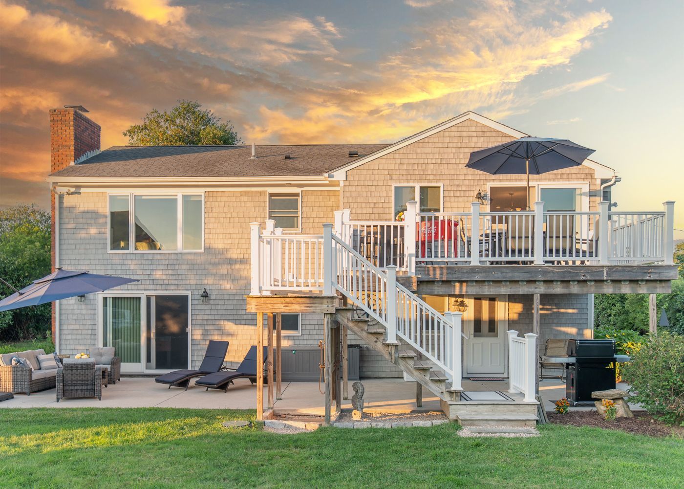 The back of a house with a large deck and stairs.