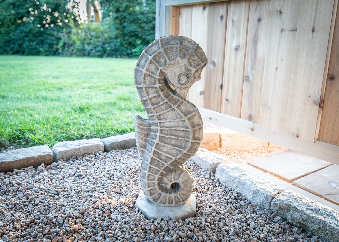 A statue of a seahorse is sitting on a pile of gravel.