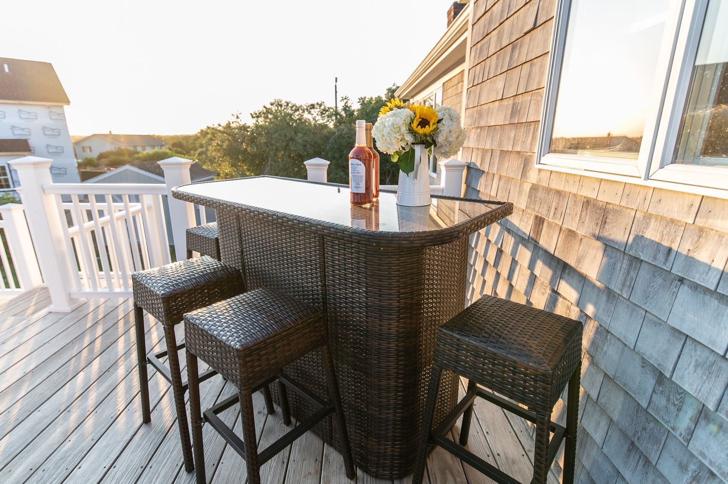 There is a table with a bottle of wine on it on the deck.