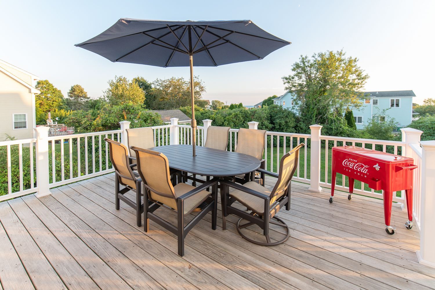 There is a table and chairs on the deck with an umbrella.