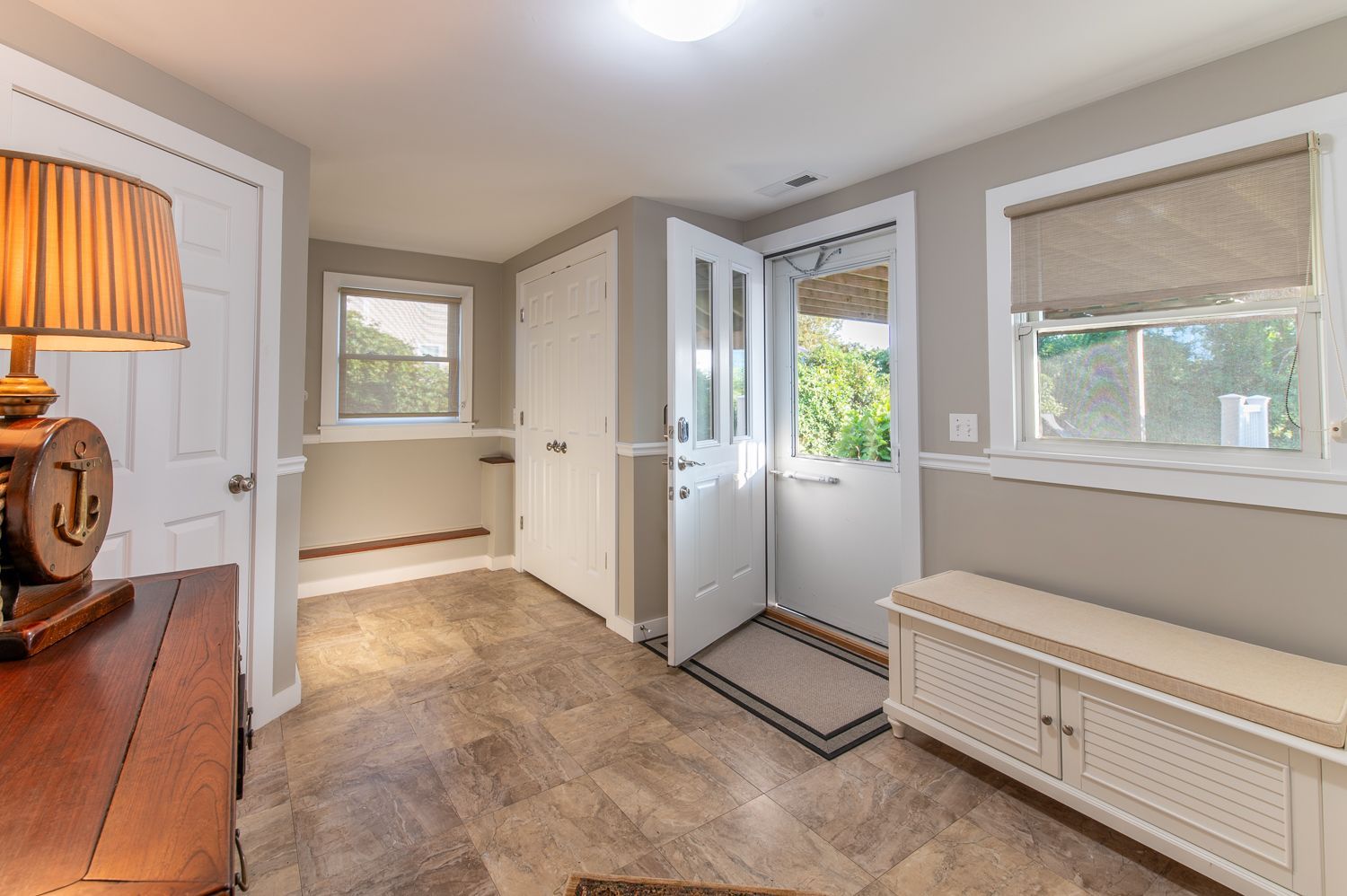A hallway with a lamp and a bench in a house.