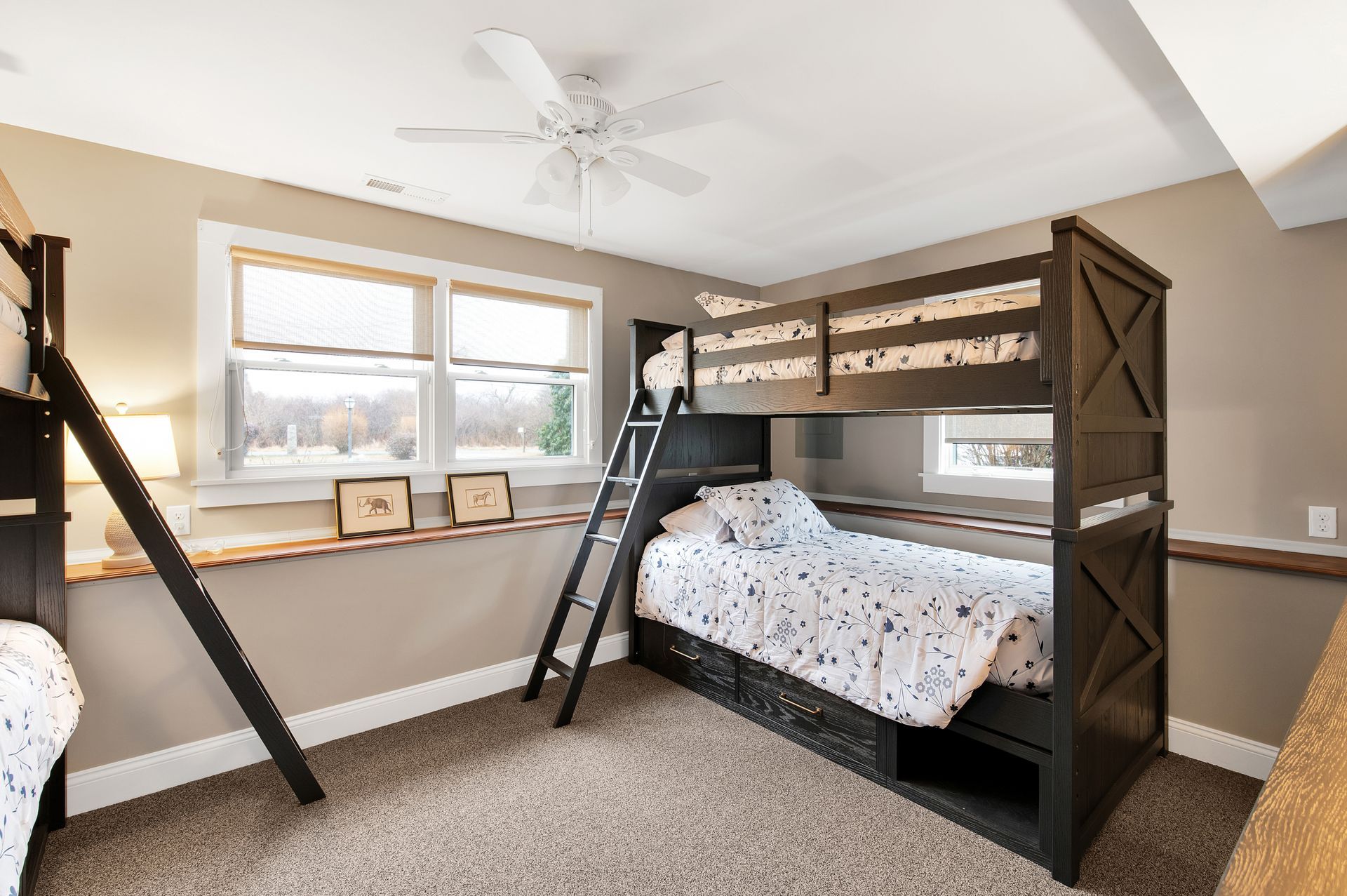 A bedroom with two bunk beds and a ceiling fan.
