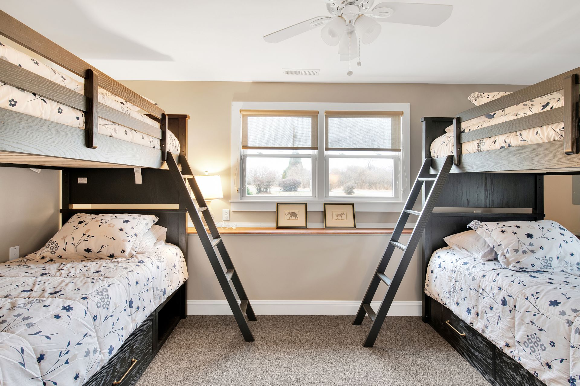 A bedroom with three bunk beds and a ceiling fan.