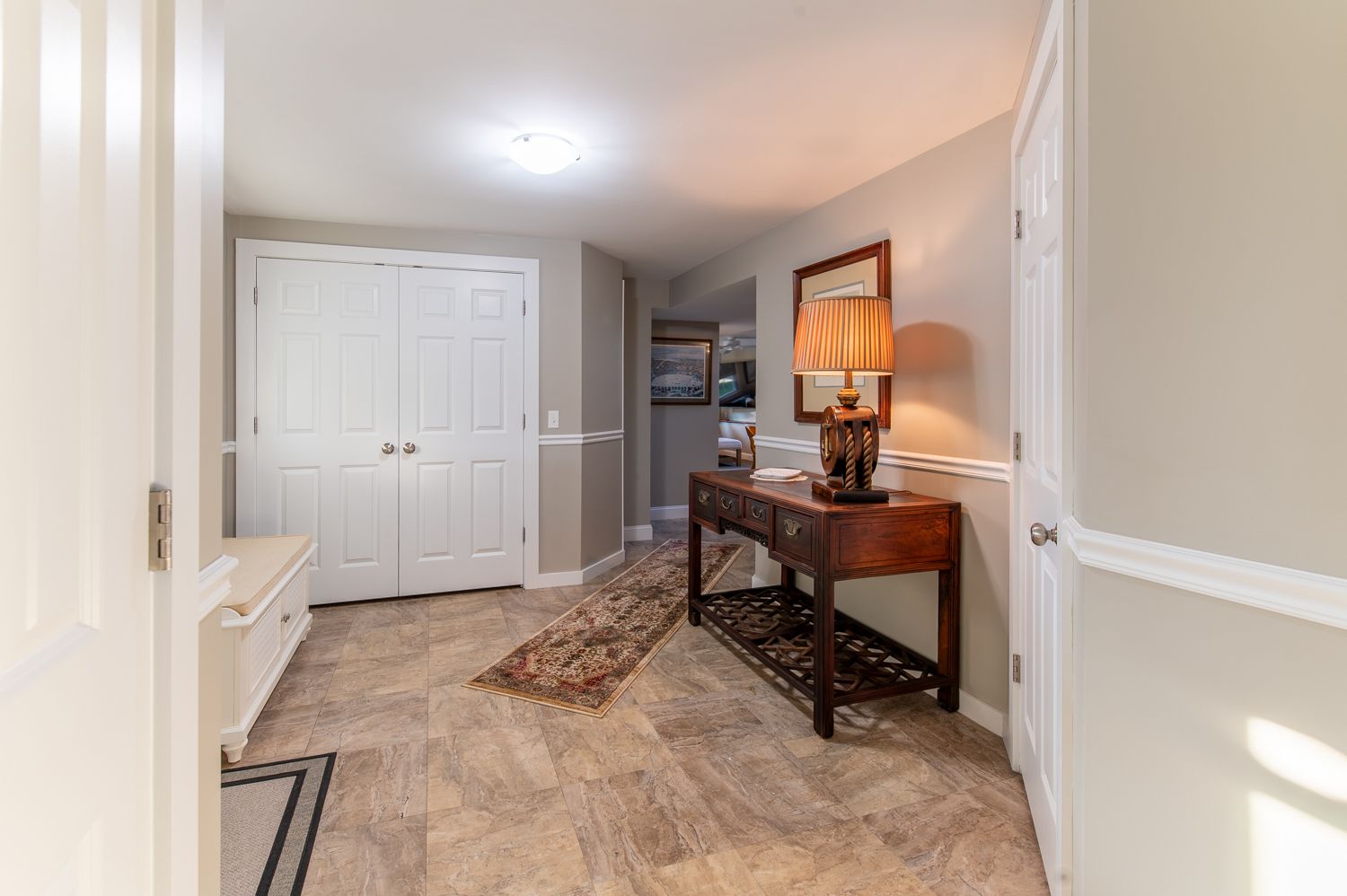 A hallway with a table and a lamp in it.