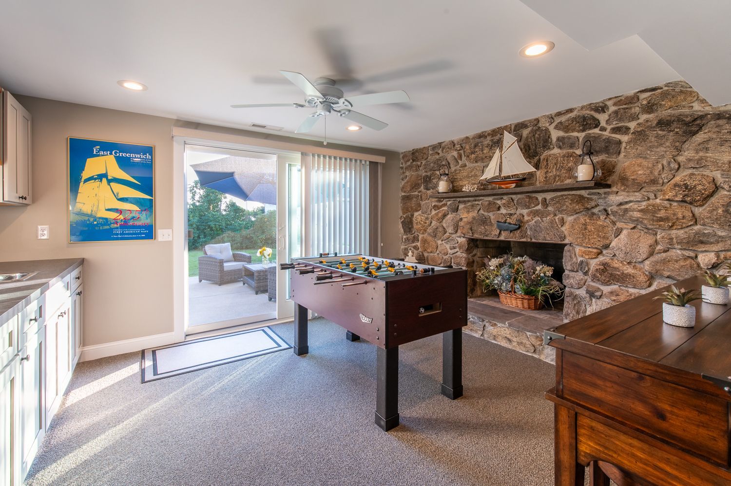 A living room with a foosball table and a fireplace.