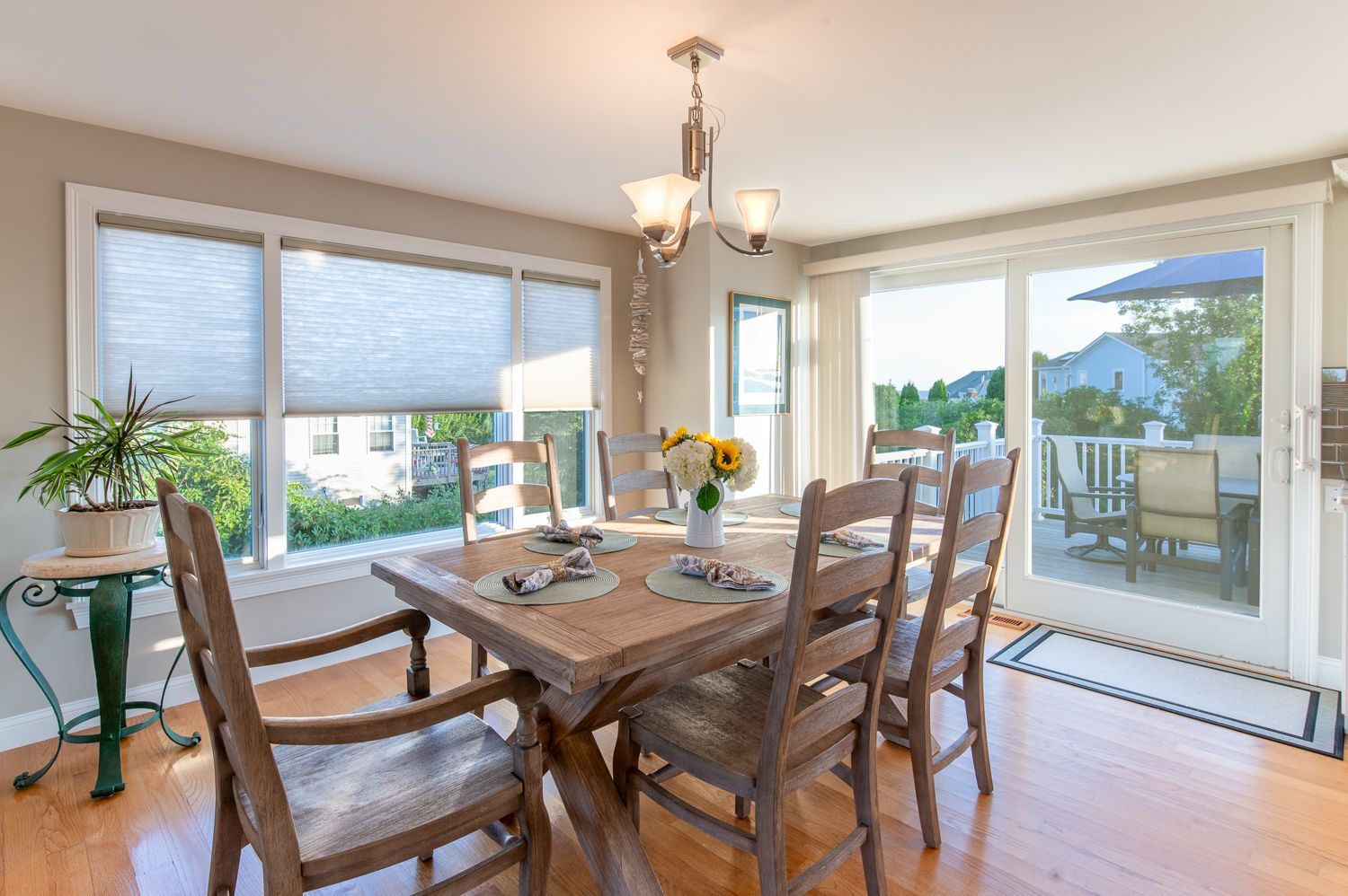 A dining room with a table and chairs and a sliding glass door.