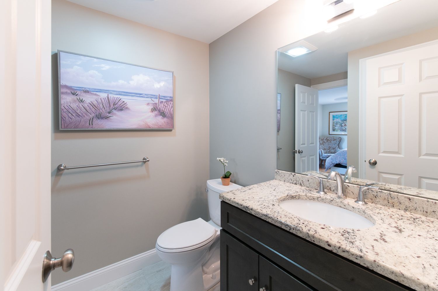 A bathroom with a toilet , sink , and mirror.