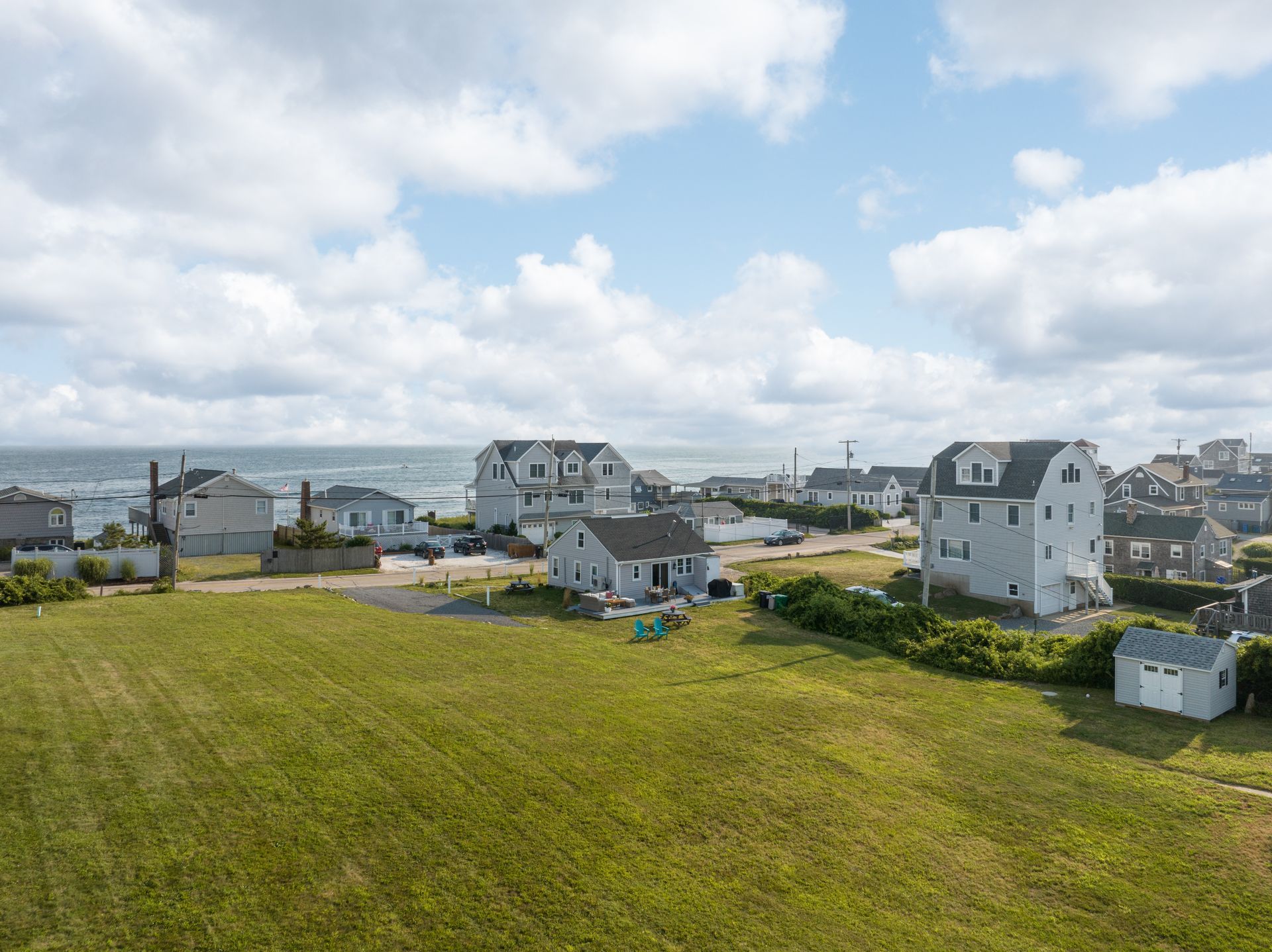 An aerial view of a residential area with houses and a large grassy field.