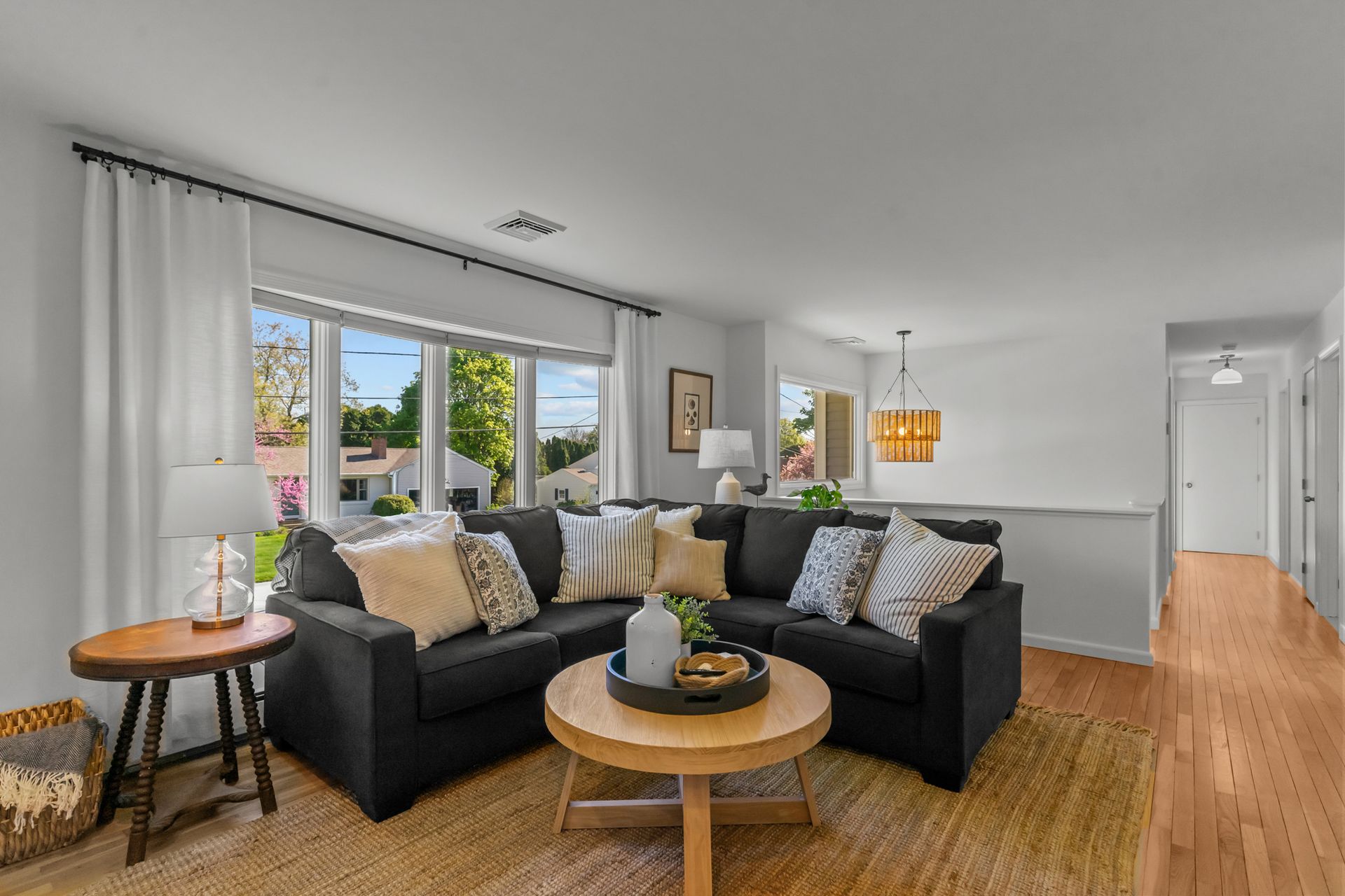 A living room with a black sectional couch and a wooden coffee table.