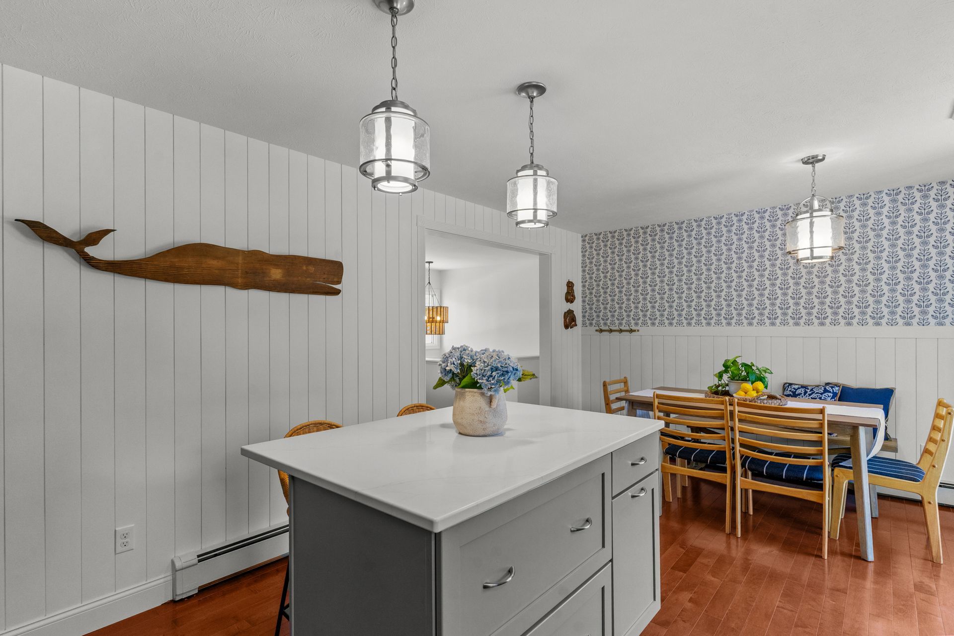 A kitchen with a large island and a whale hanging on the wall.