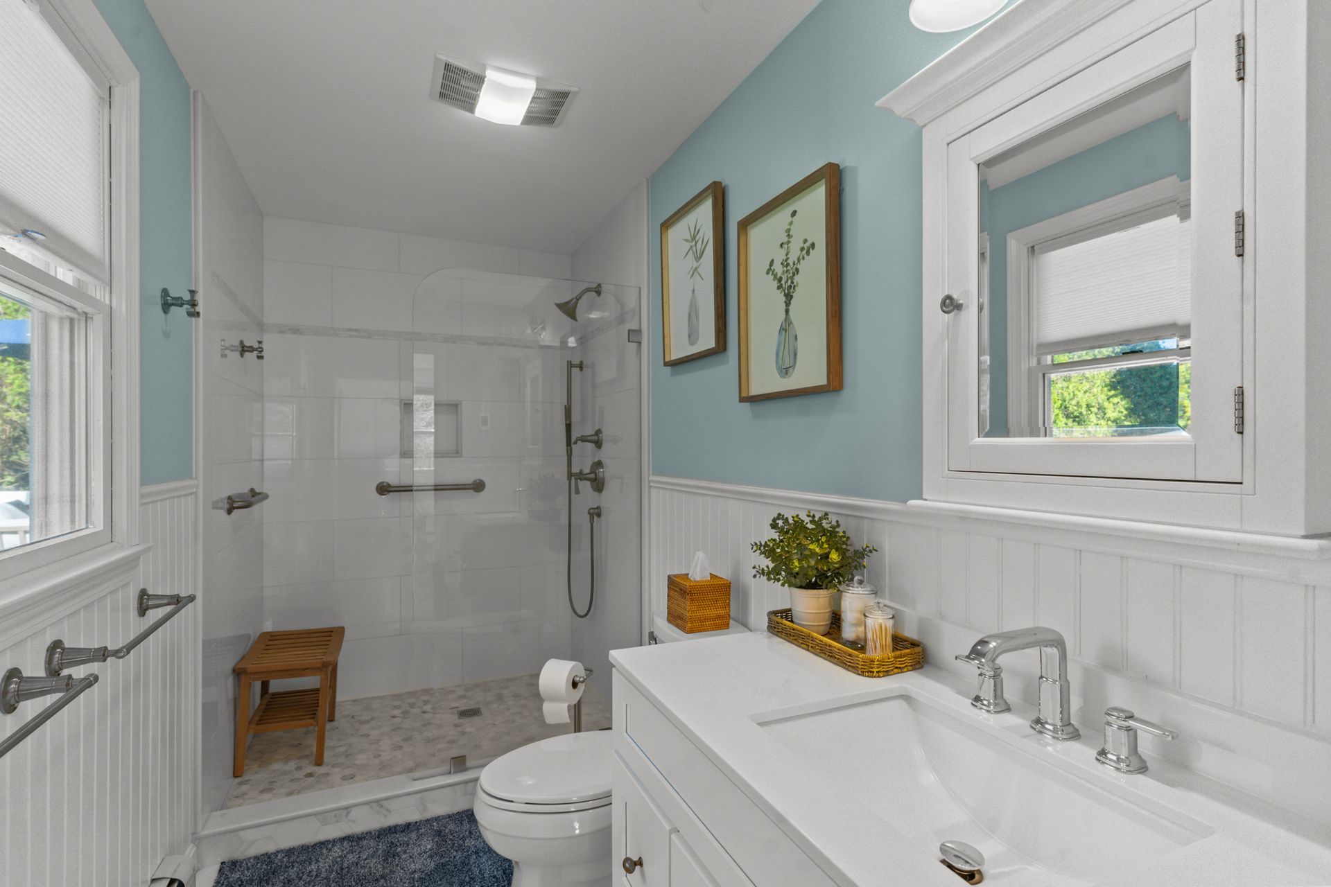 A bathroom with a toilet , sink , and walk in shower.