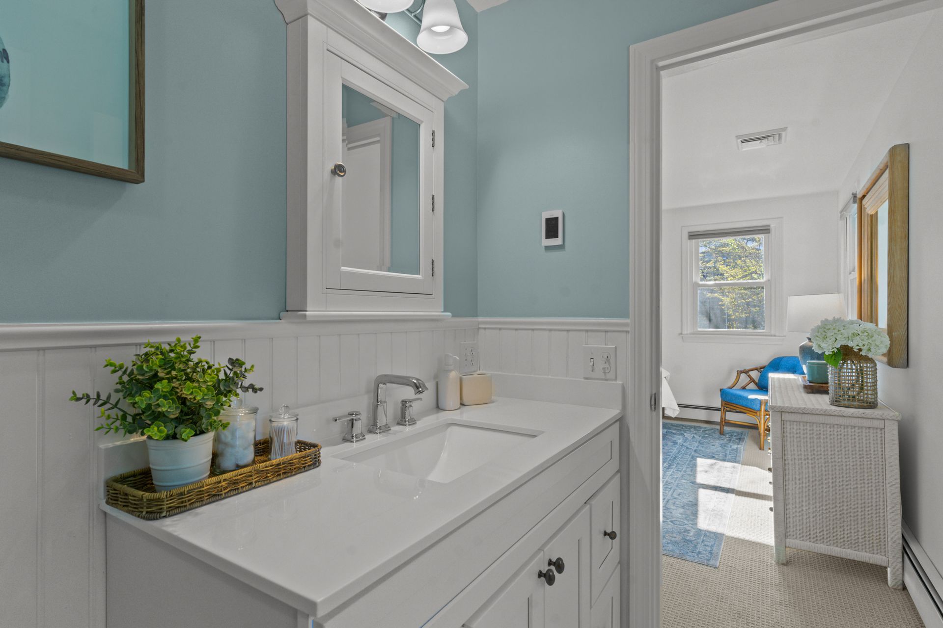 A bathroom with a sink , mirror and blue walls.