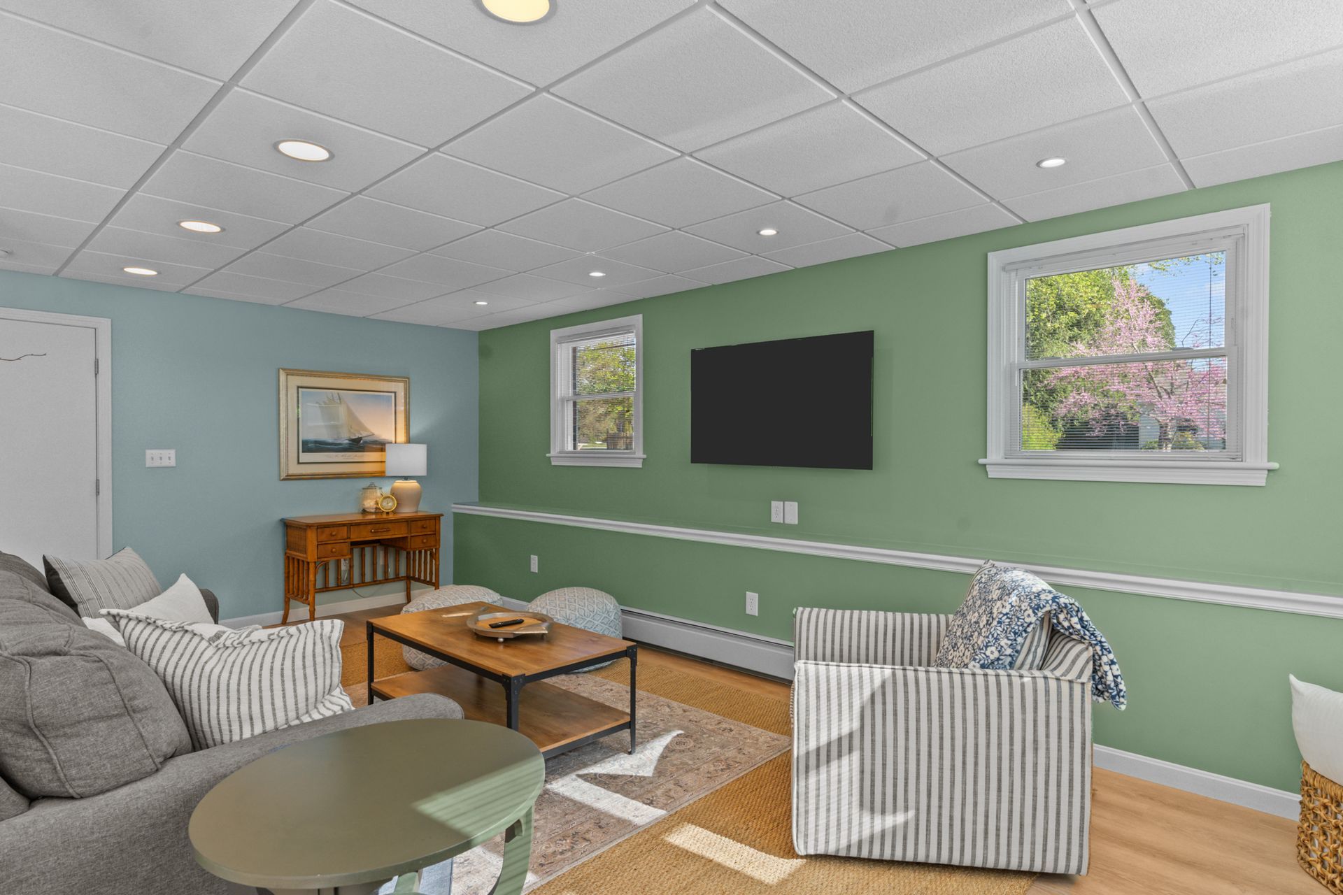 A living room with green walls and a flat screen tv.