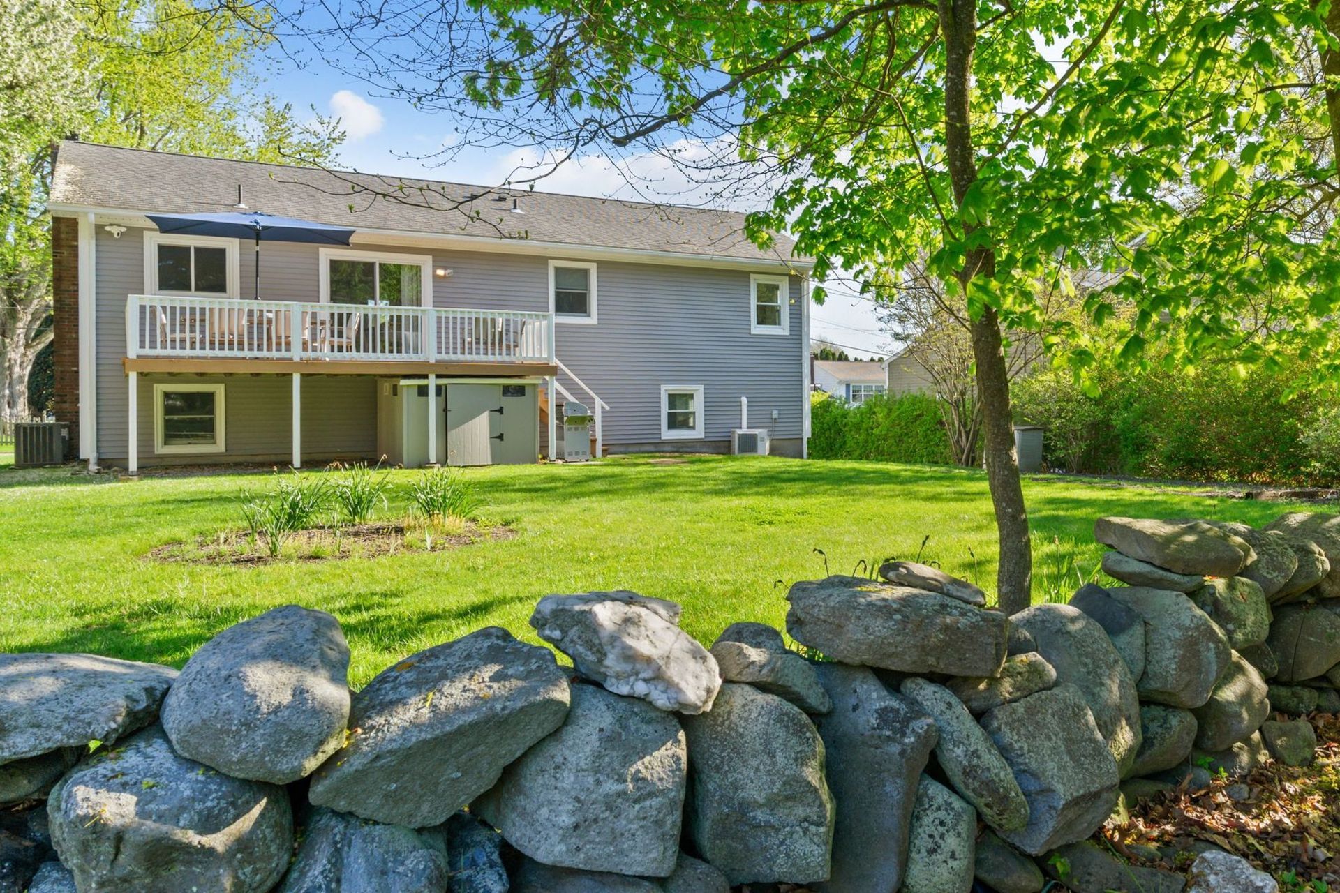 A house with a stone wall in front of it