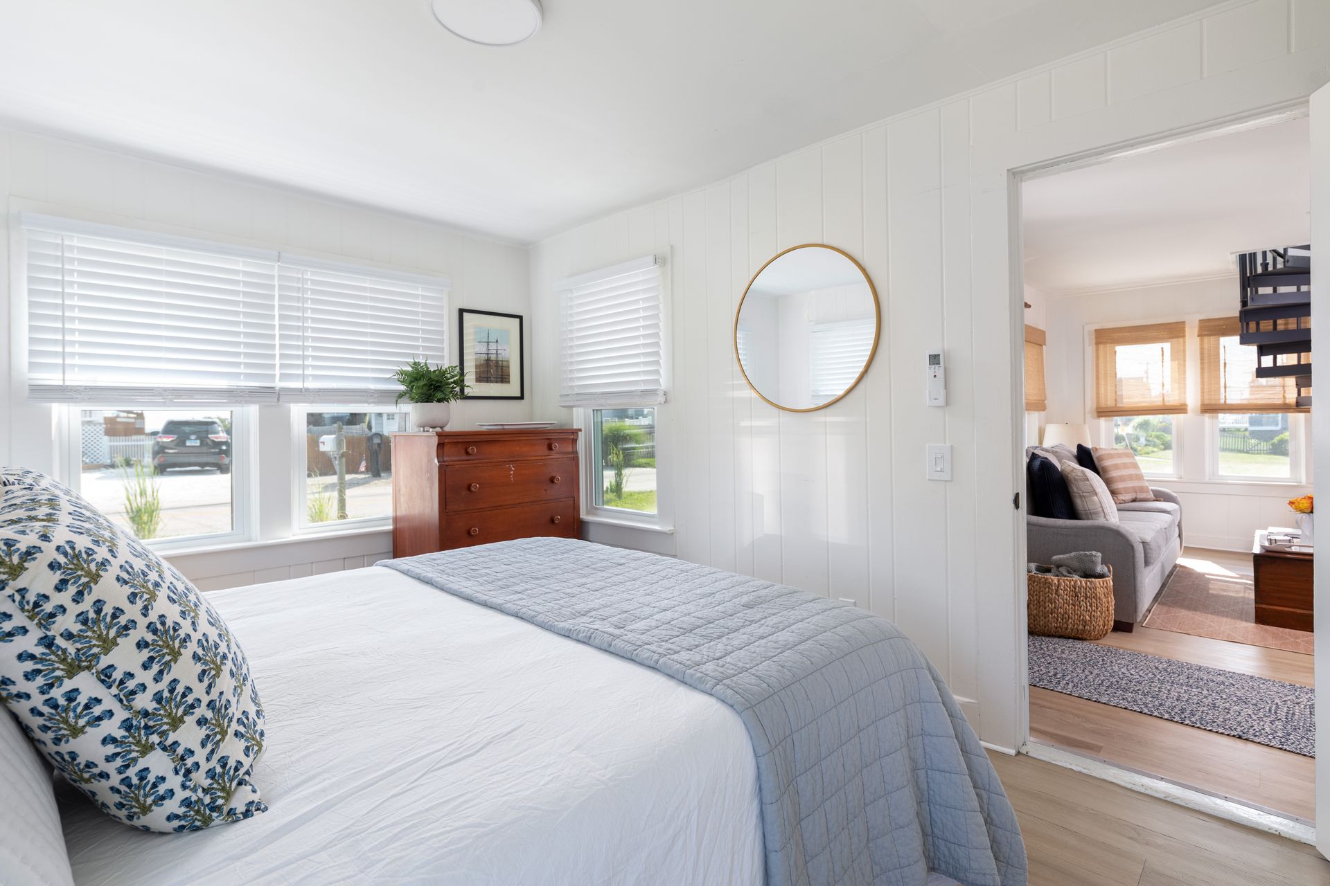 A bedroom with a bed , dresser , and mirror.