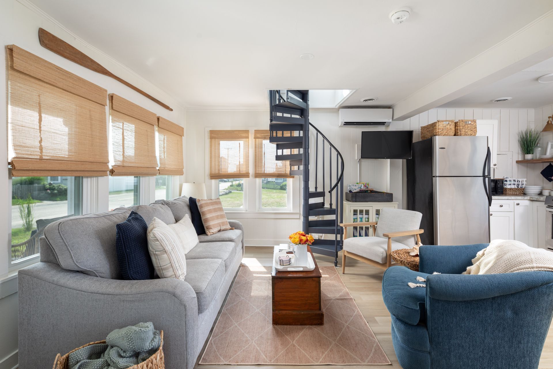 A living room with a spiral staircase leading to the second floor.
