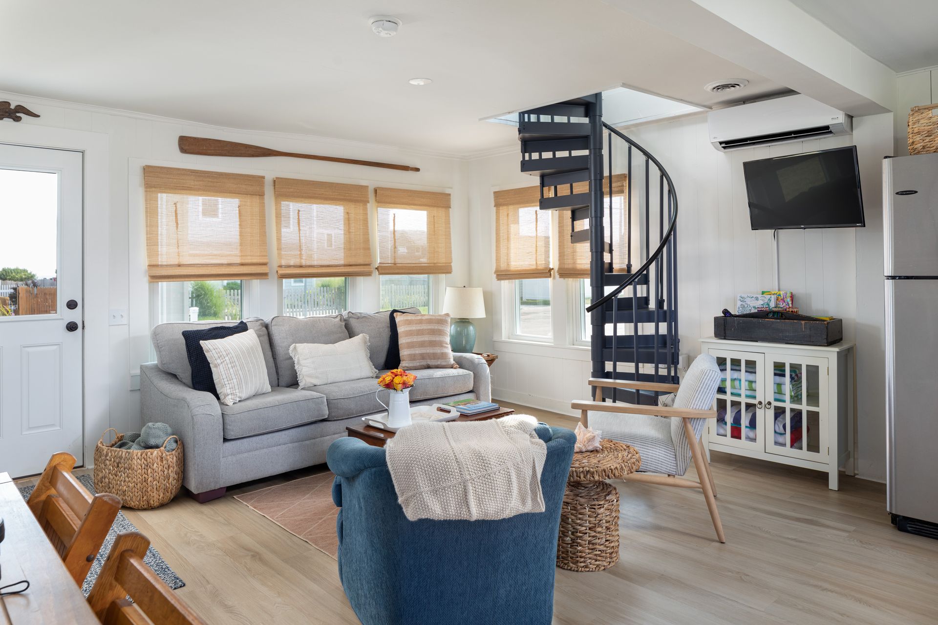 A living room with a spiral staircase leading to the second floor.
