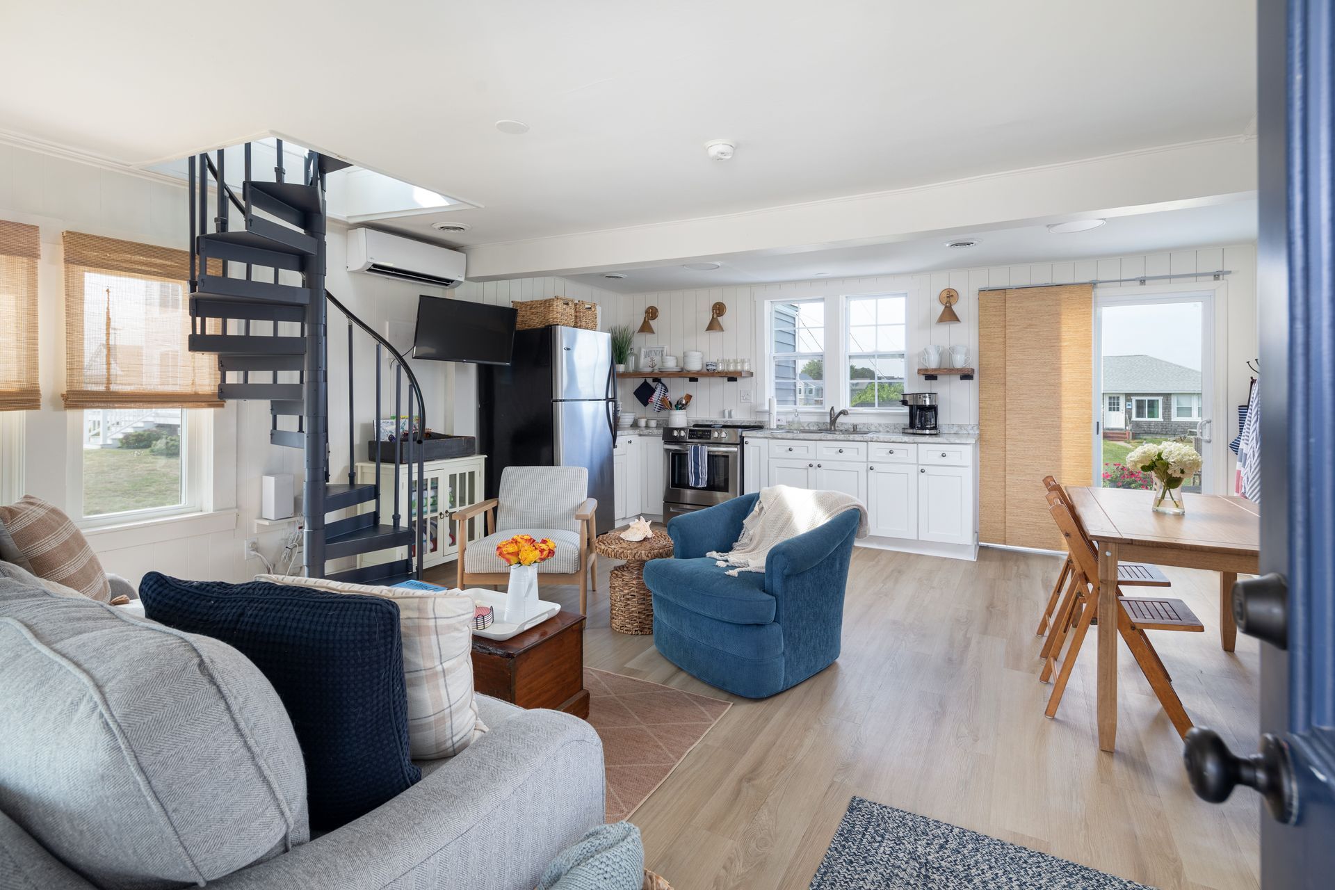 A living room with a spiral staircase leading to the second floor.