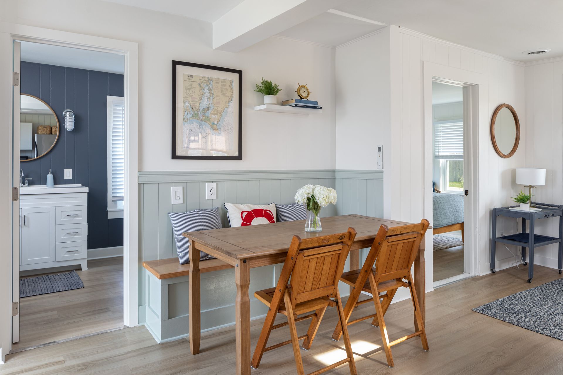 A dining room with a table and chairs and a bench.