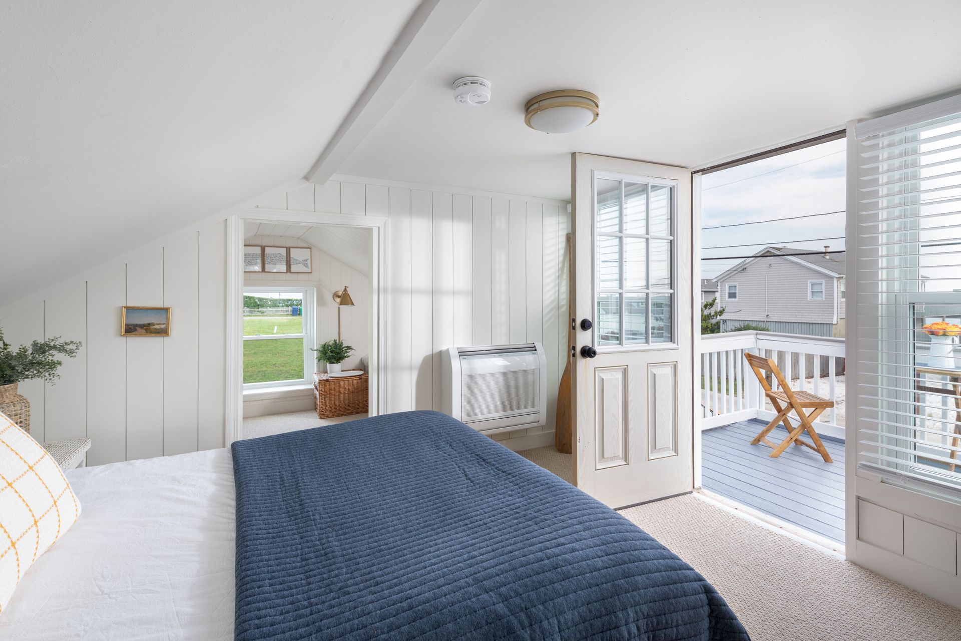 A bedroom with a king size bed and a balcony.