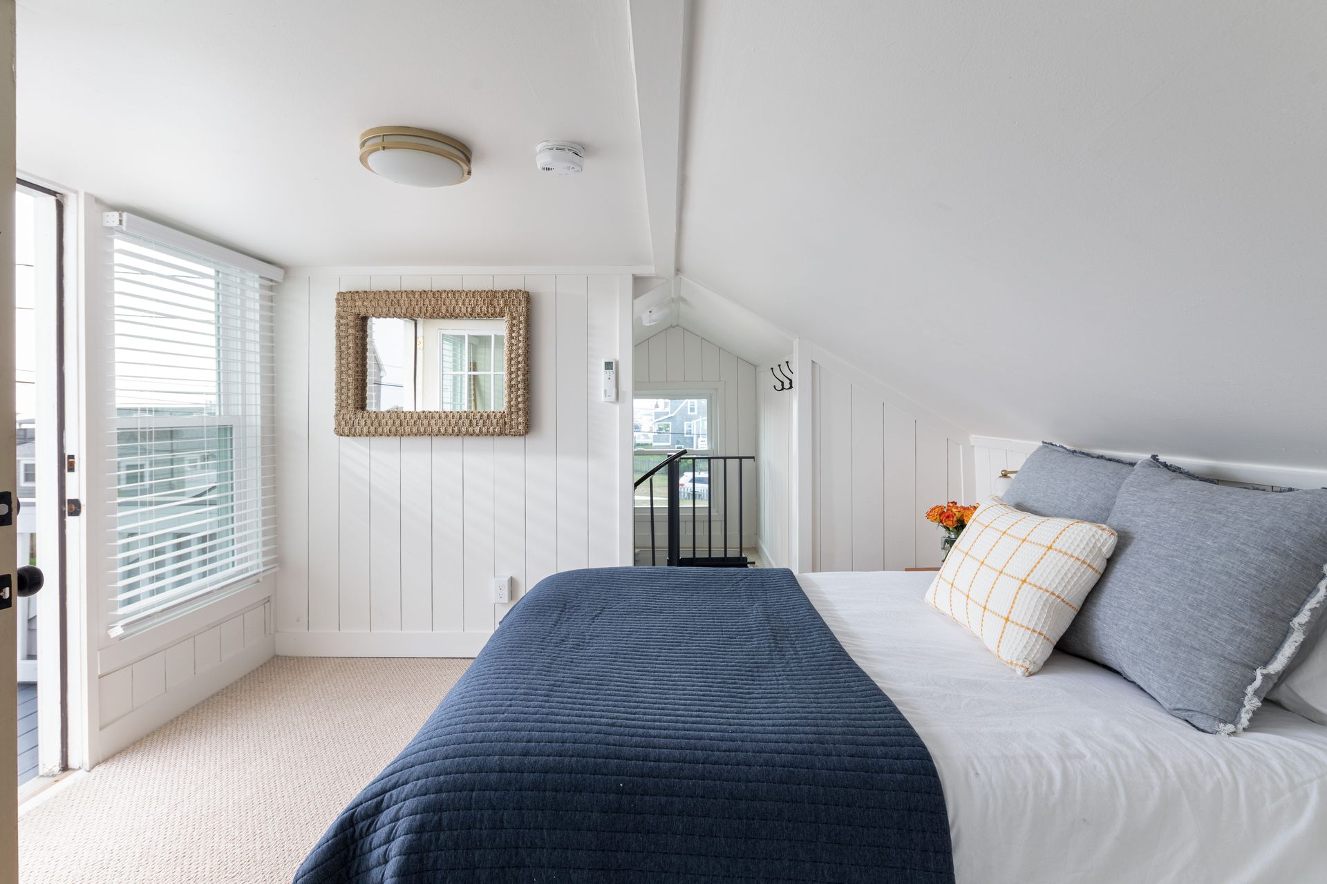 A bedroom with a bed and a mirror on the wall.