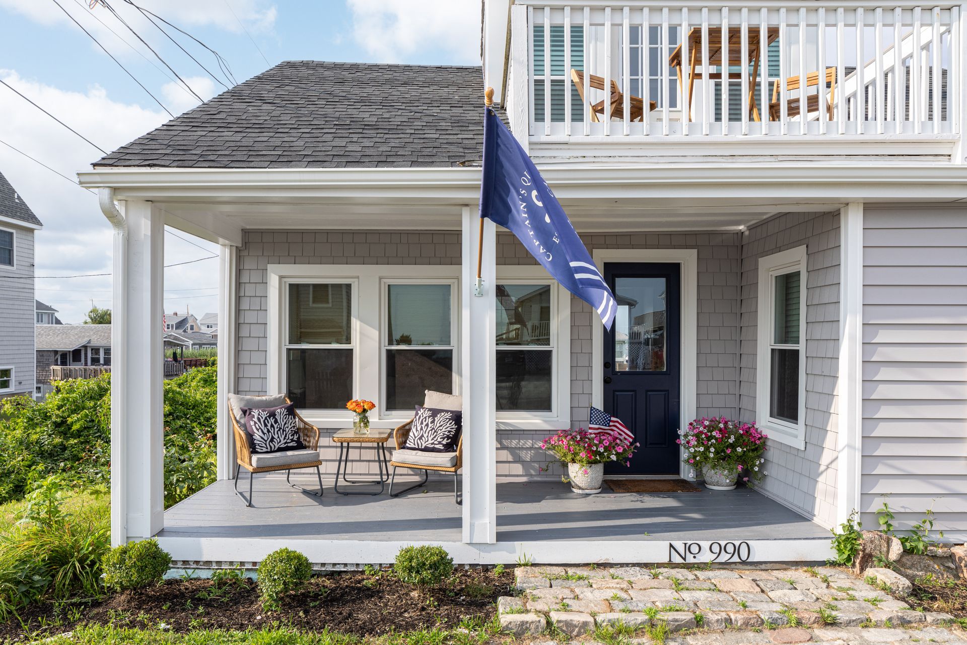 A small house with a porch and a blue flag on it.