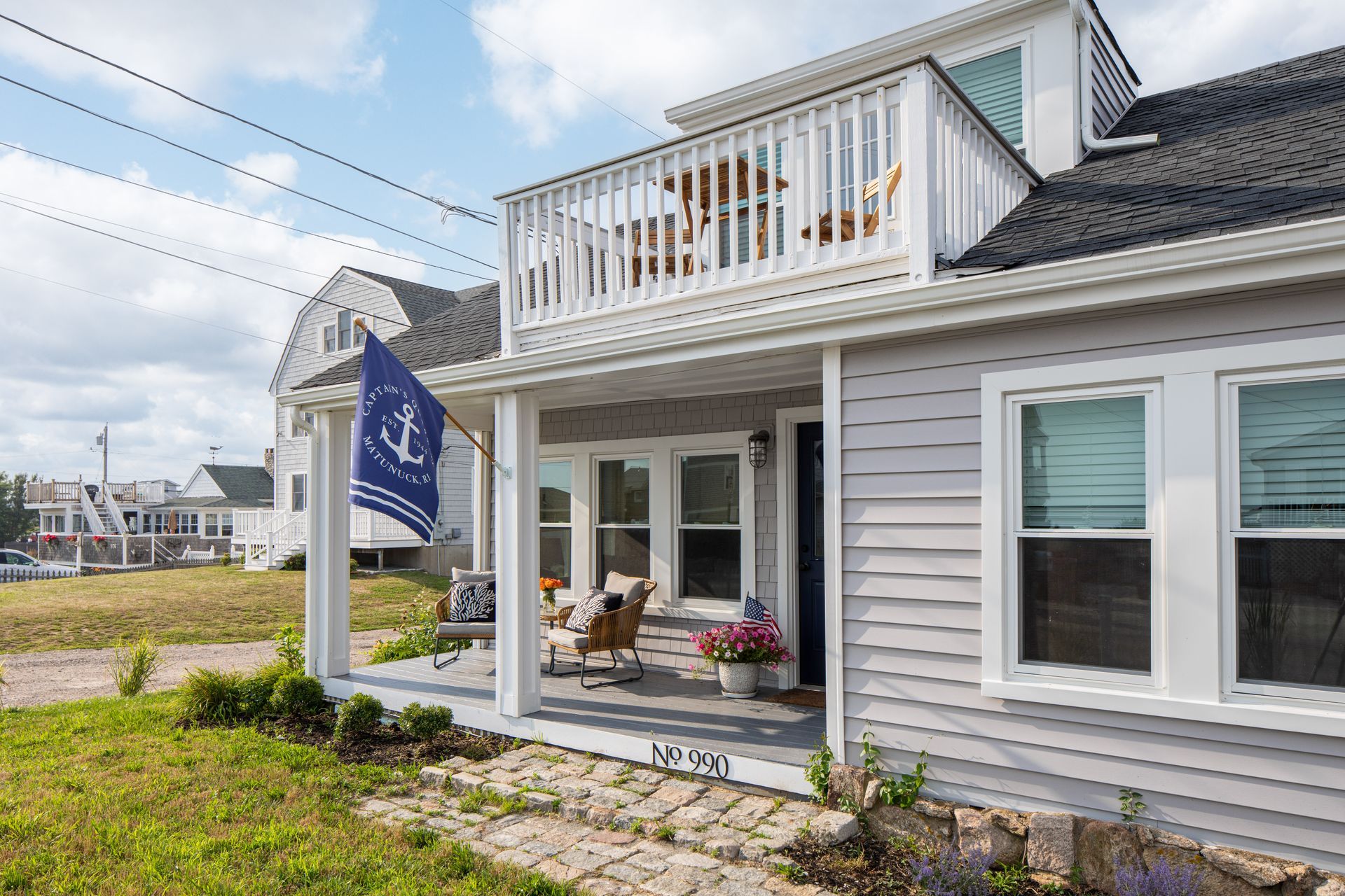 A house with a balcony and a flag on the porch.