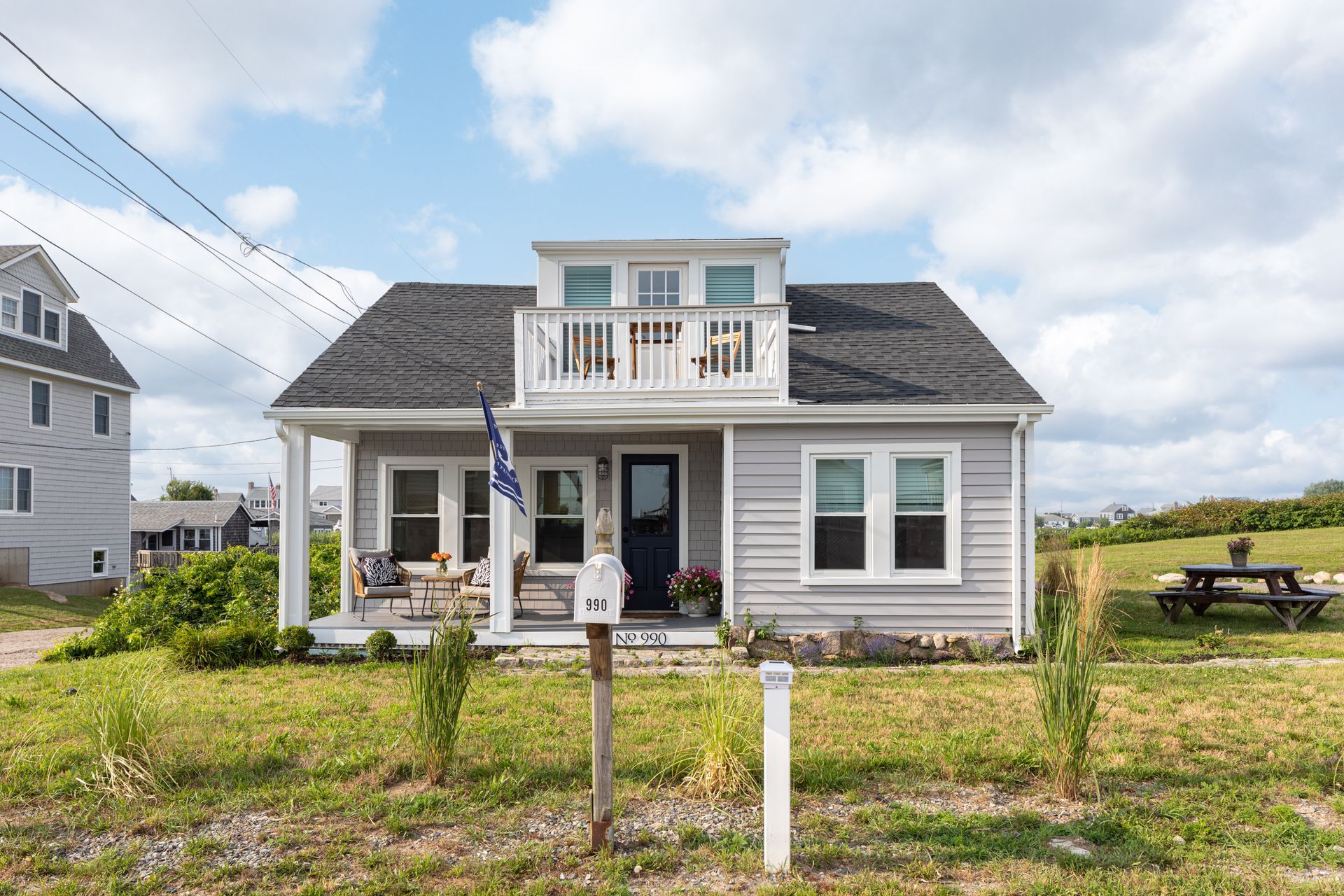 A small house with a porch and a mailbox in front of it.
