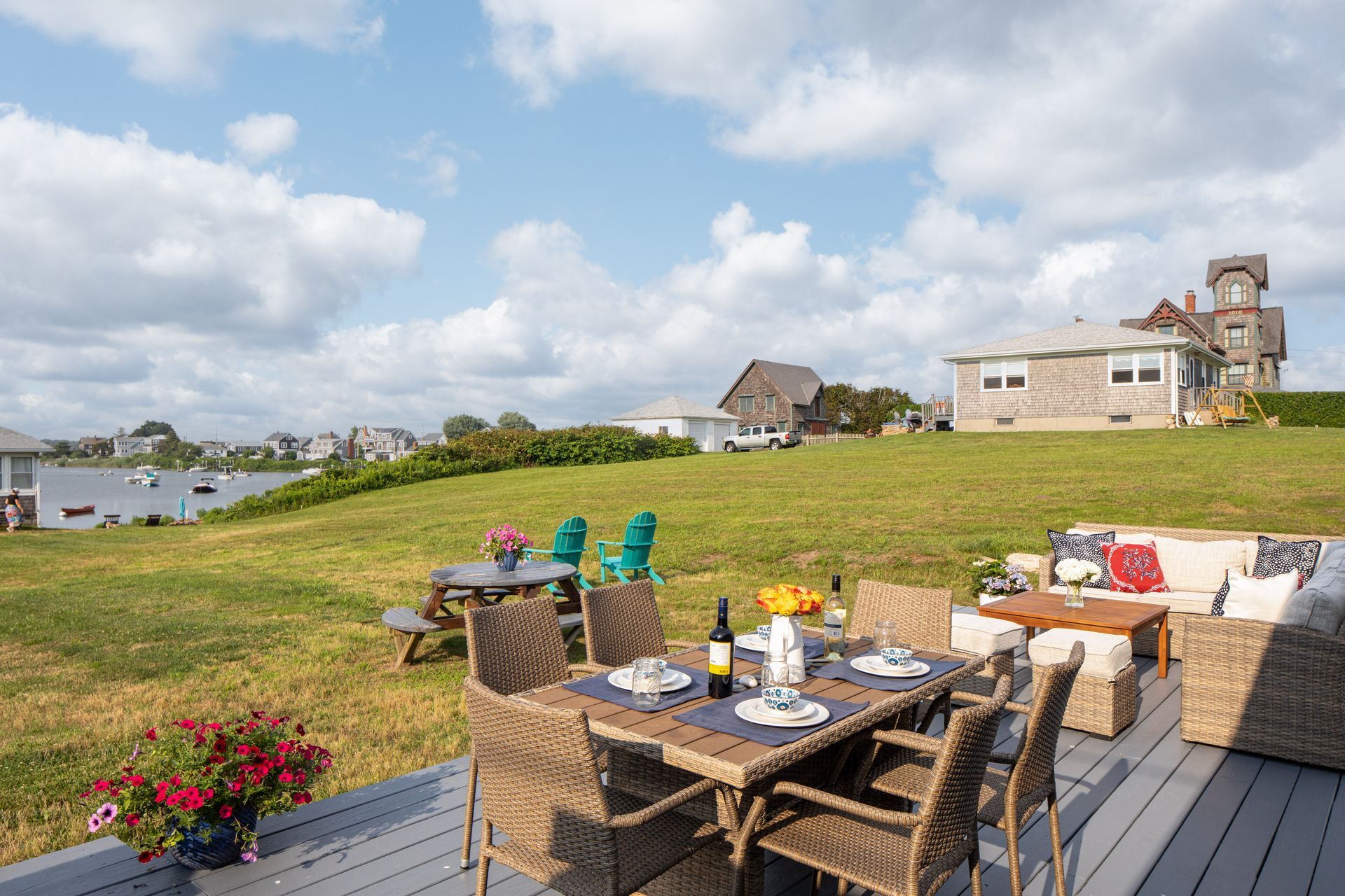 There is a table and chairs on the deck with a view of a field.