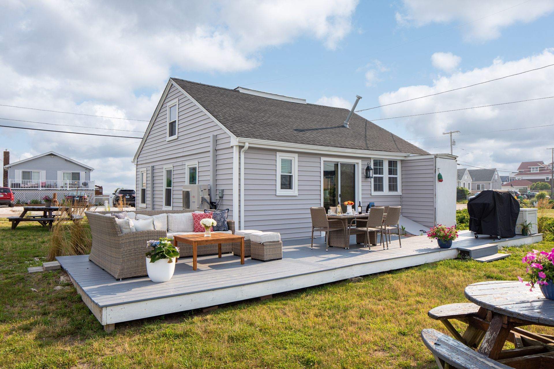 A small house with a large deck in front of it.