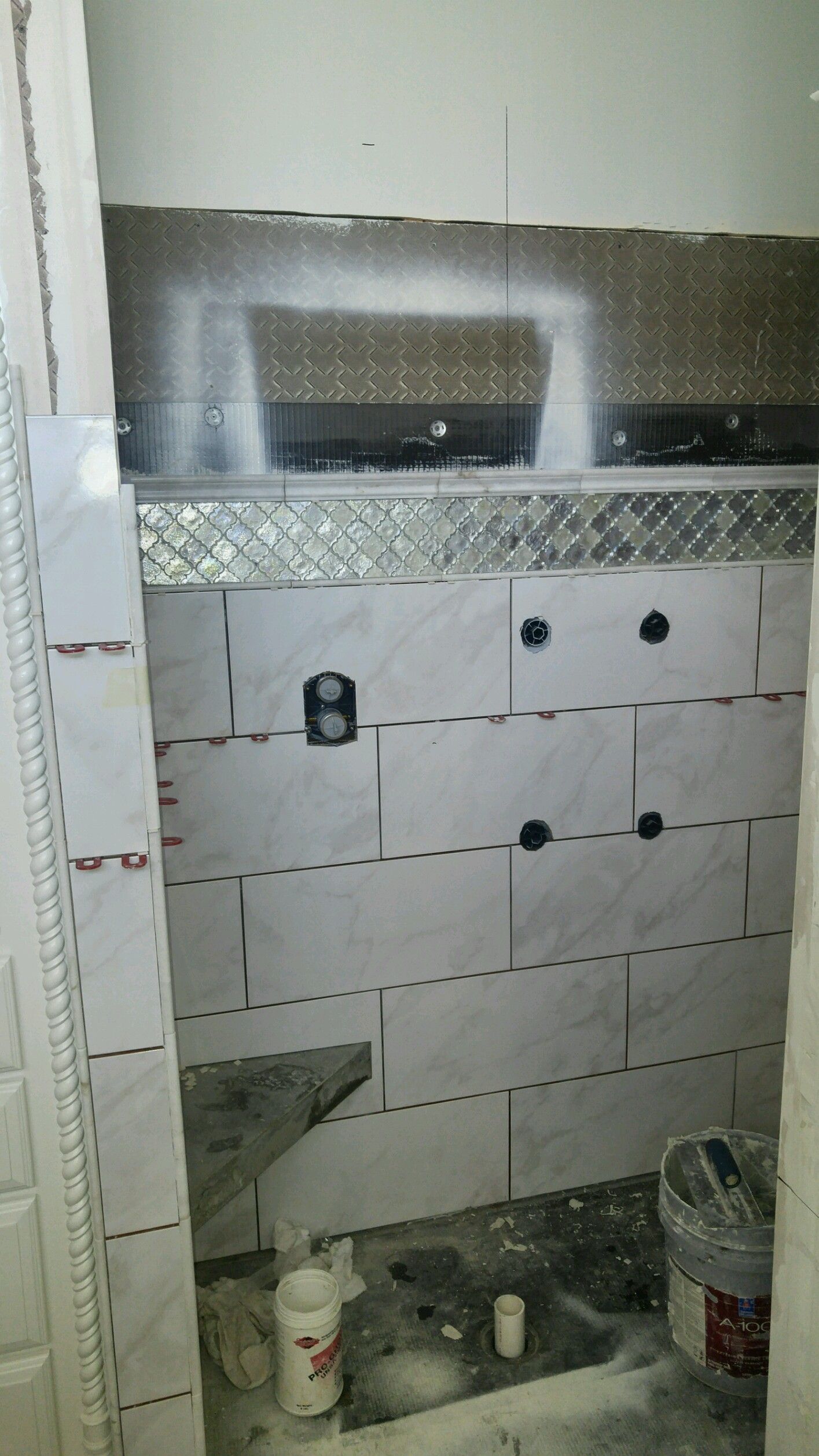 A bathroom is being remodeled with tiles and a sink.