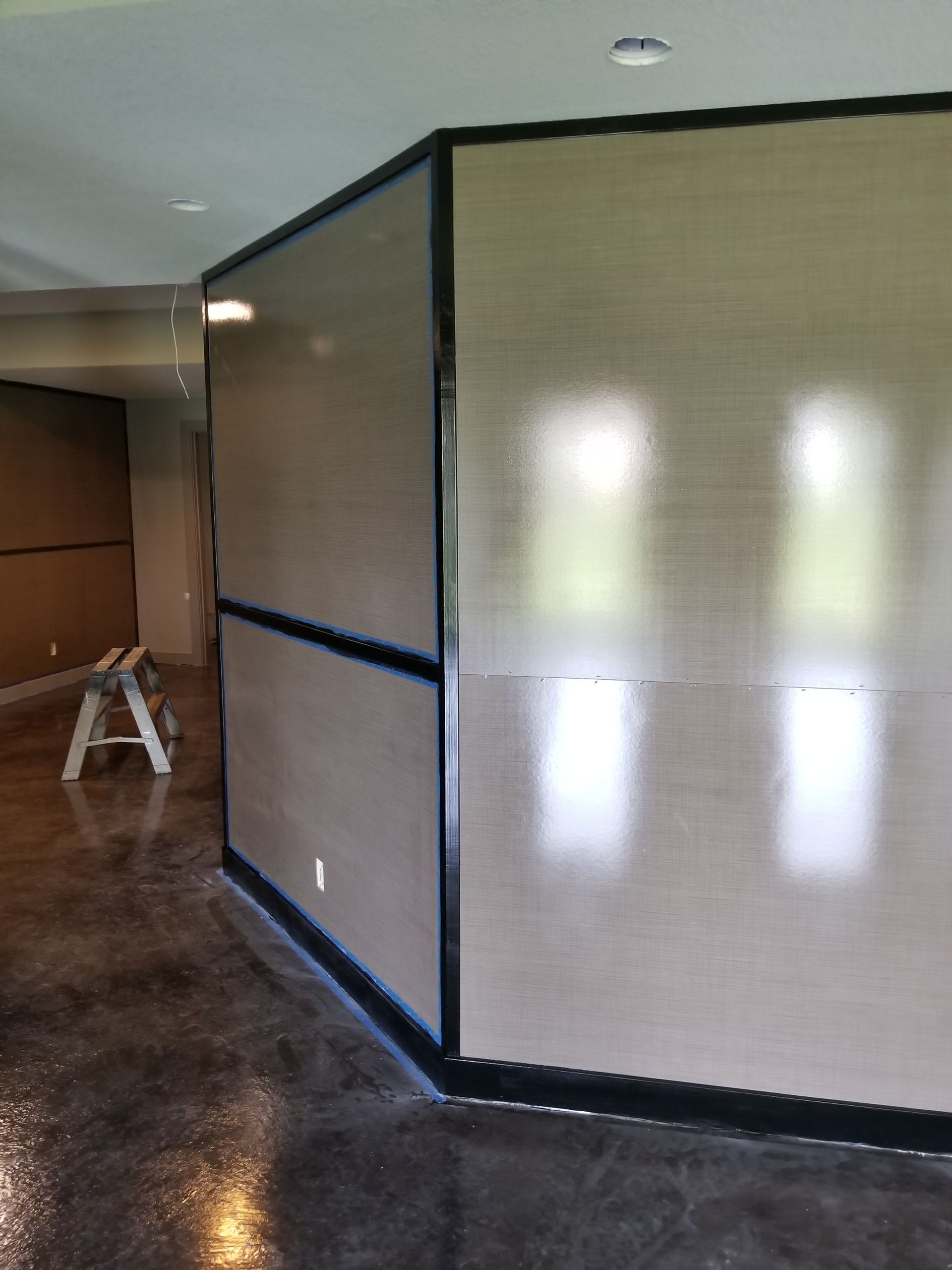 A corner of a room with a ladder in the background.