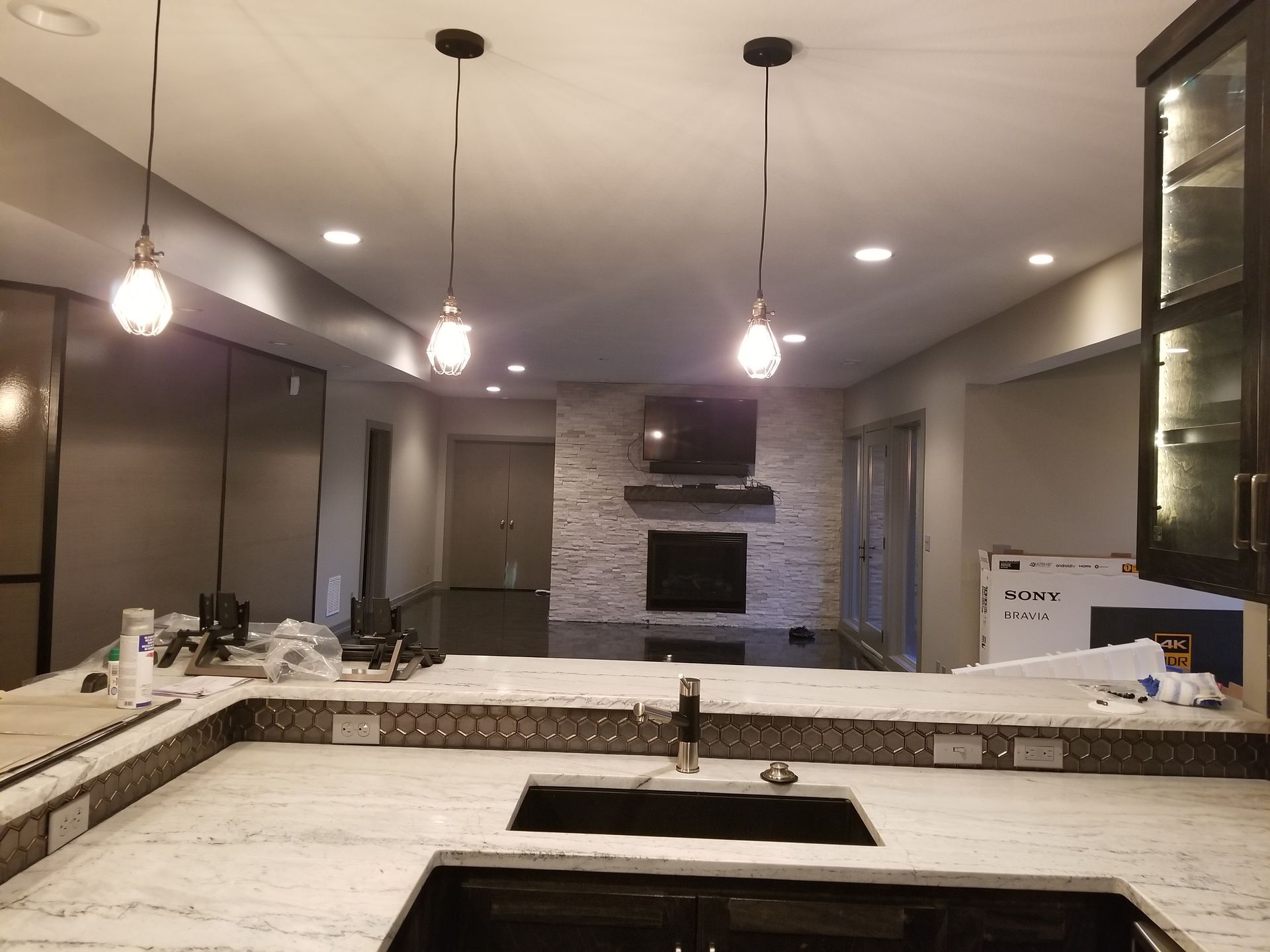A kitchen with white counter tops and a black sink