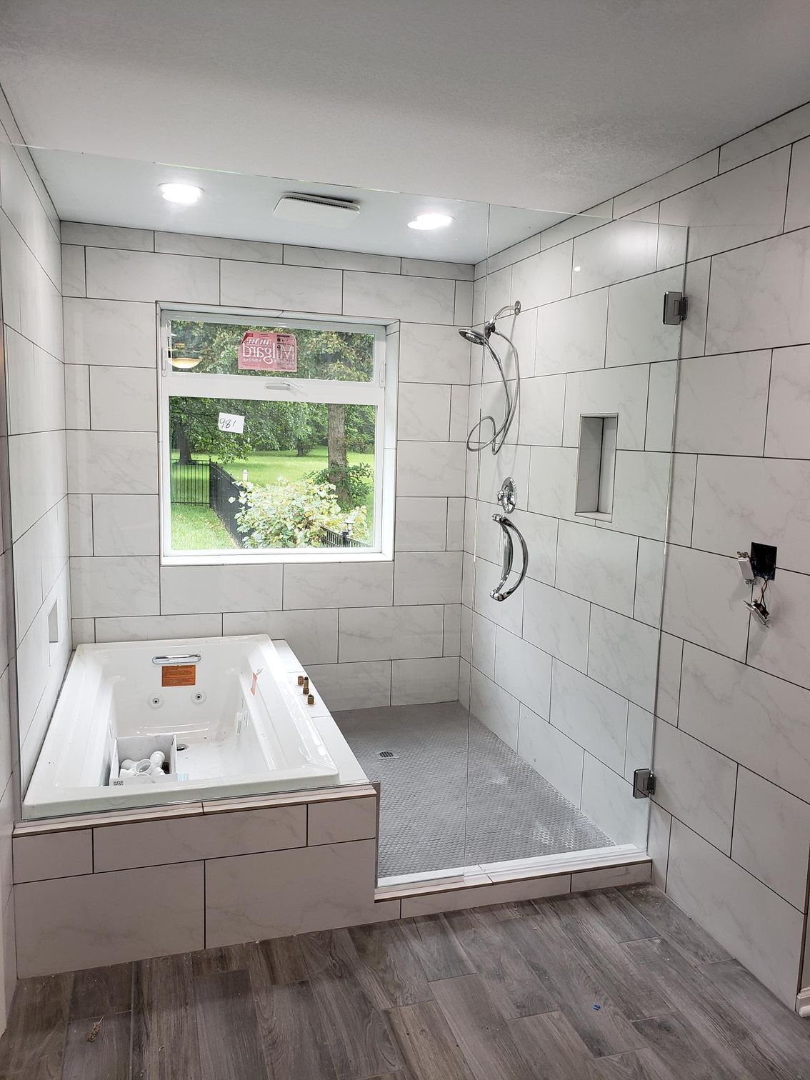 A bathroom with a tub and a walk in shower.