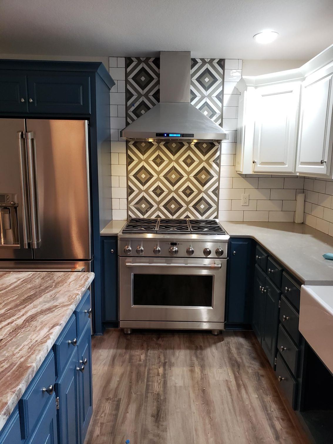 A kitchen with stainless steel appliances and blue cabinets