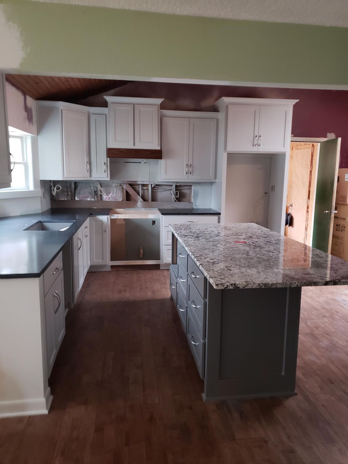 A kitchen with granite counter tops and white cabinets