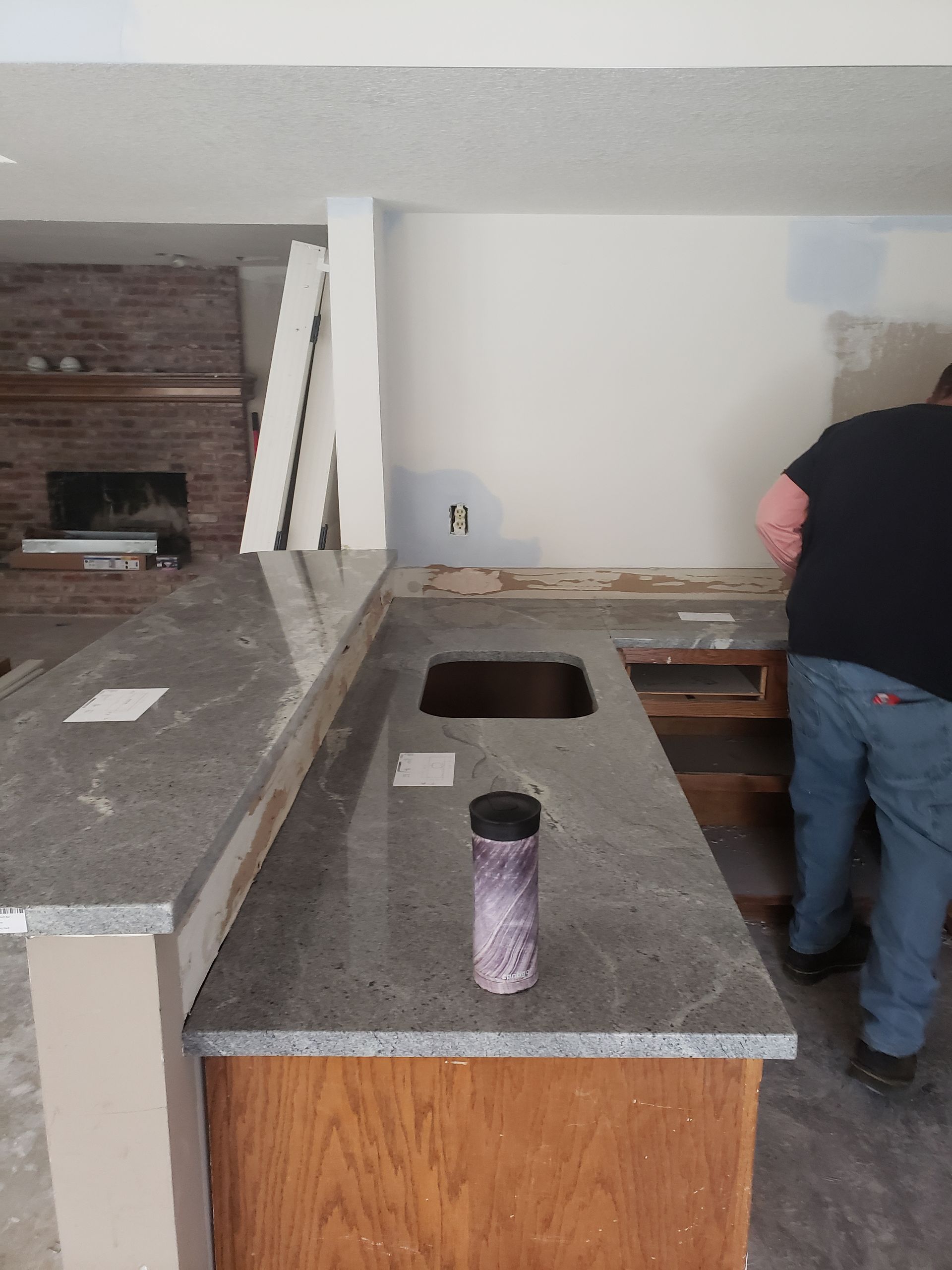 A man in a black shirt is working on a kitchen counter.