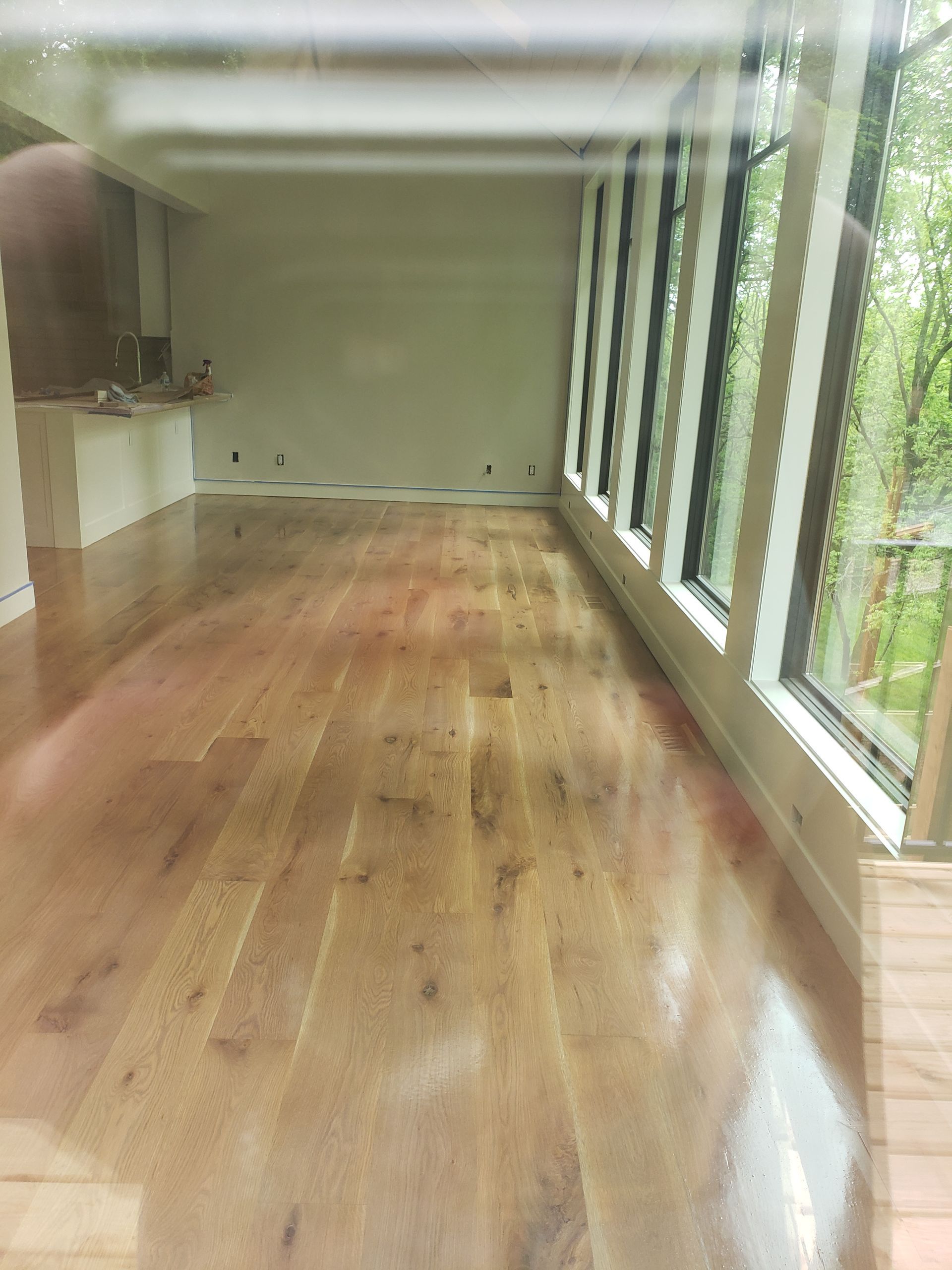 A large empty room with wooden floors and lots of windows.