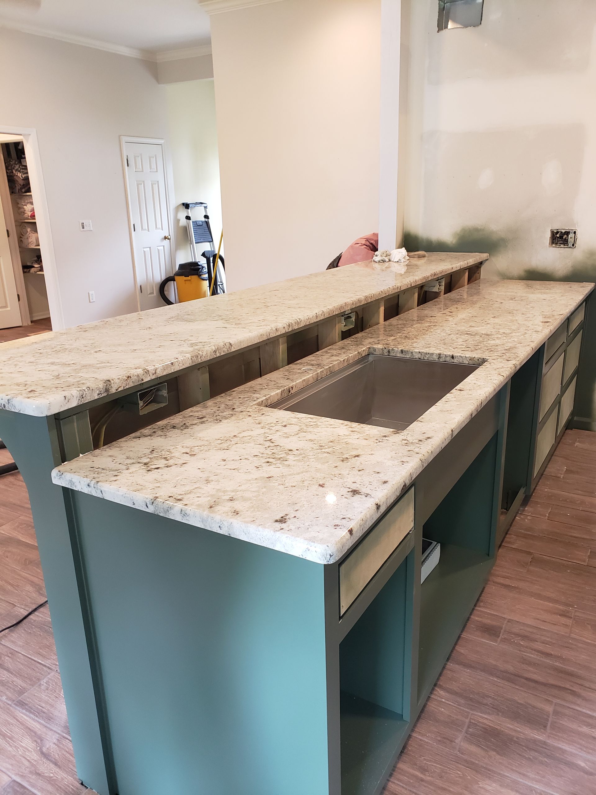 A kitchen with granite counter tops and a stainless steel sink.