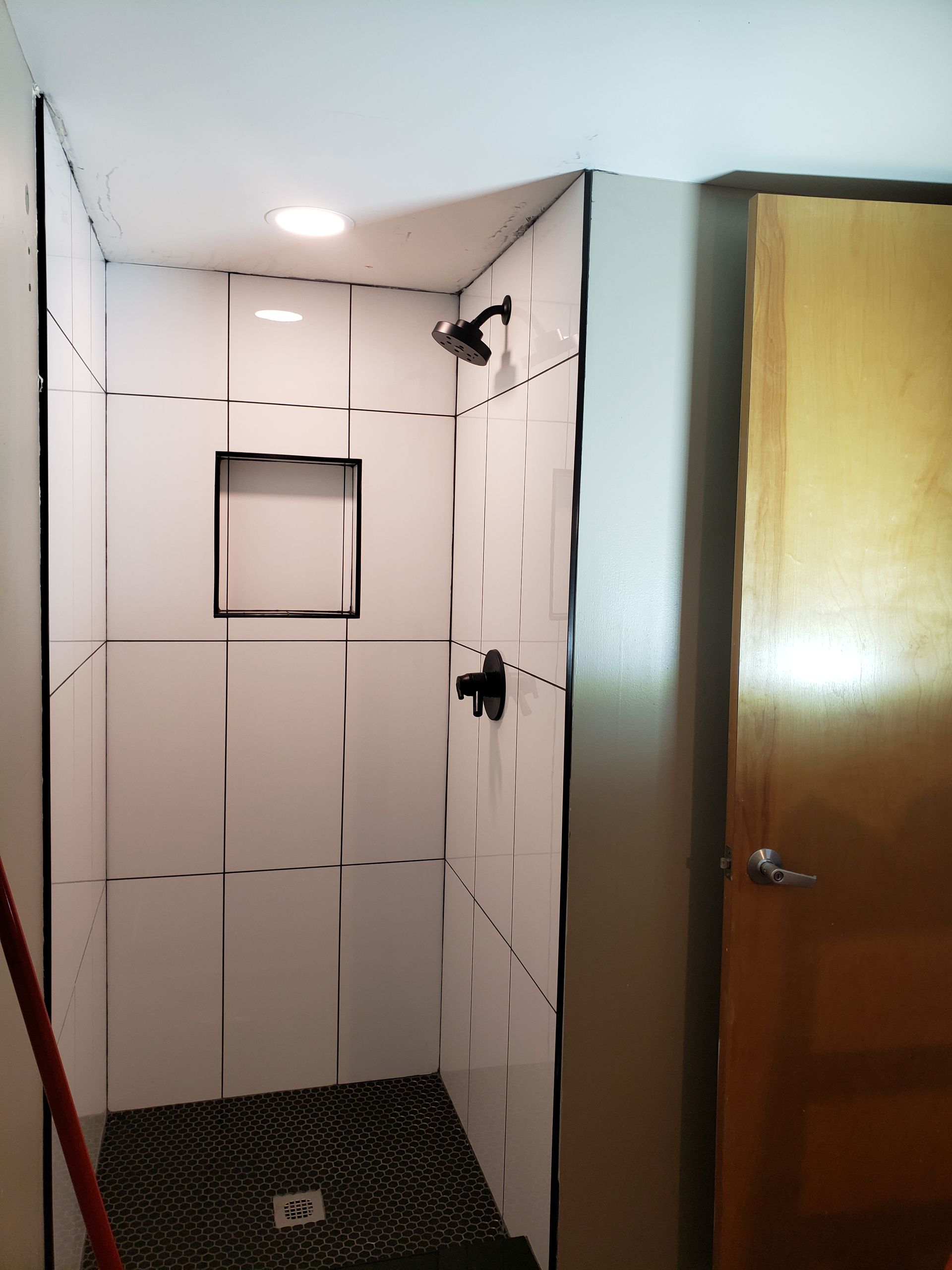 A bathroom with a walk in shower and a door