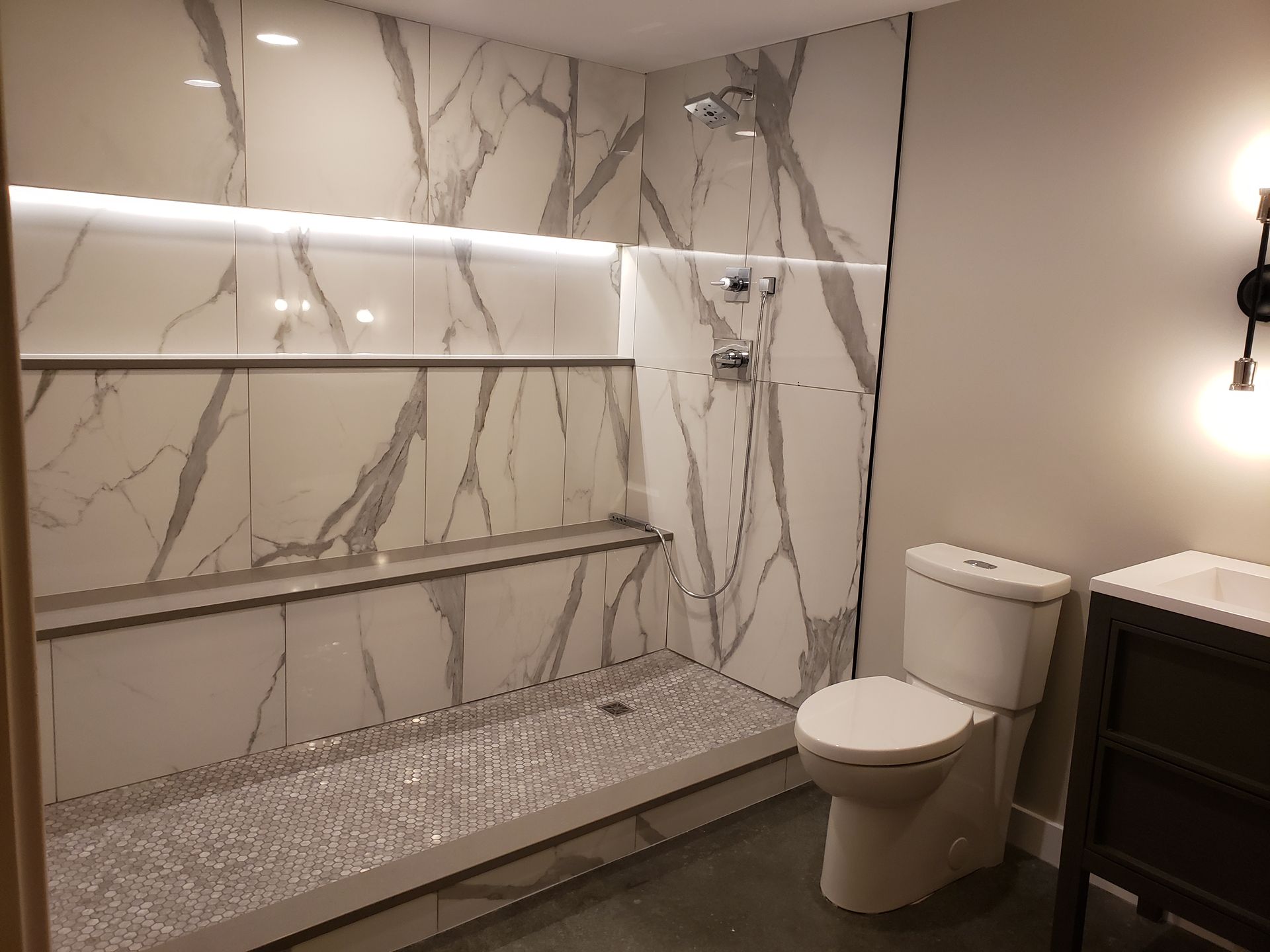 A bathroom with a toilet , sink and shower.