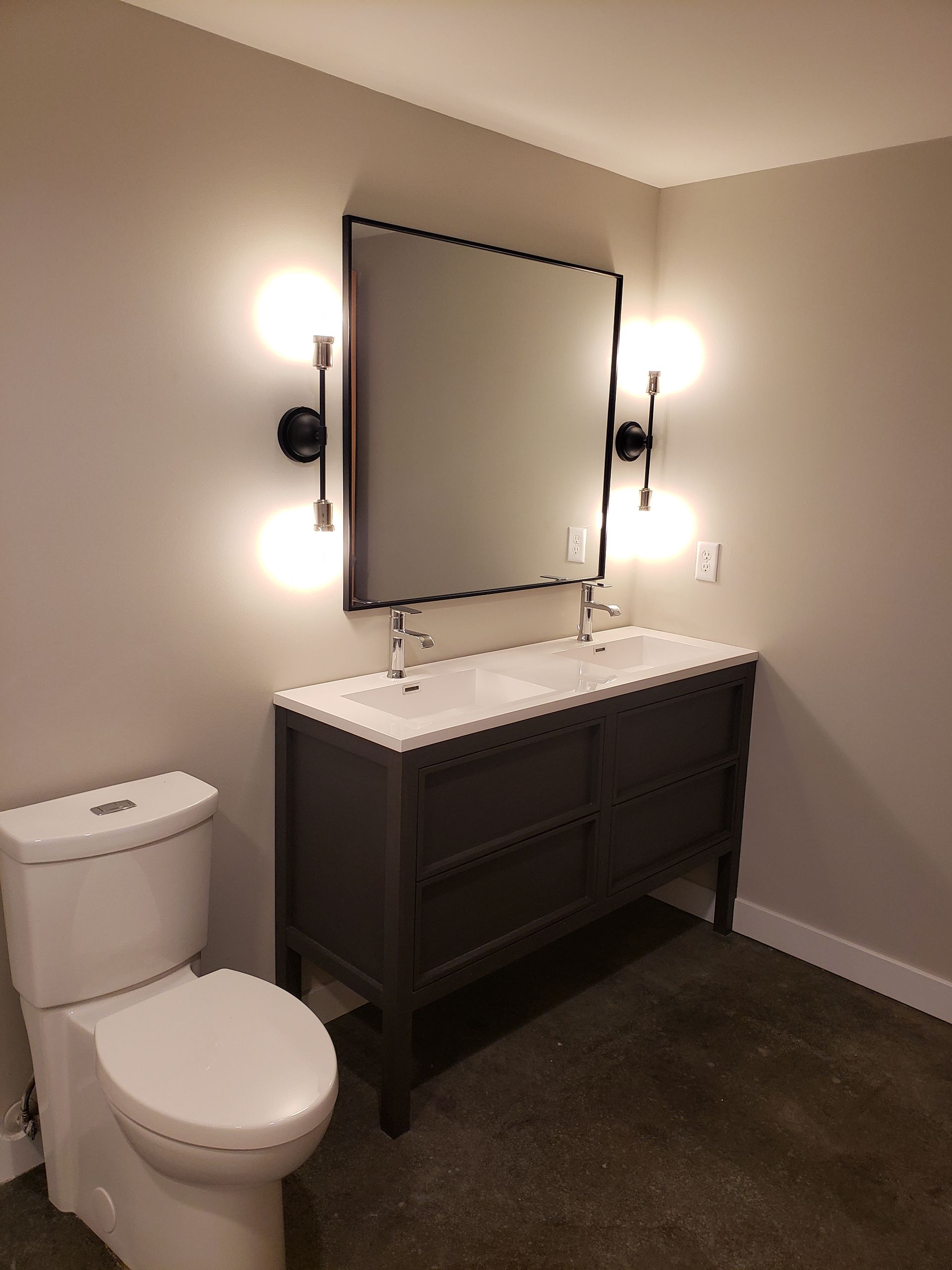 A bathroom with a toilet , sink and mirror