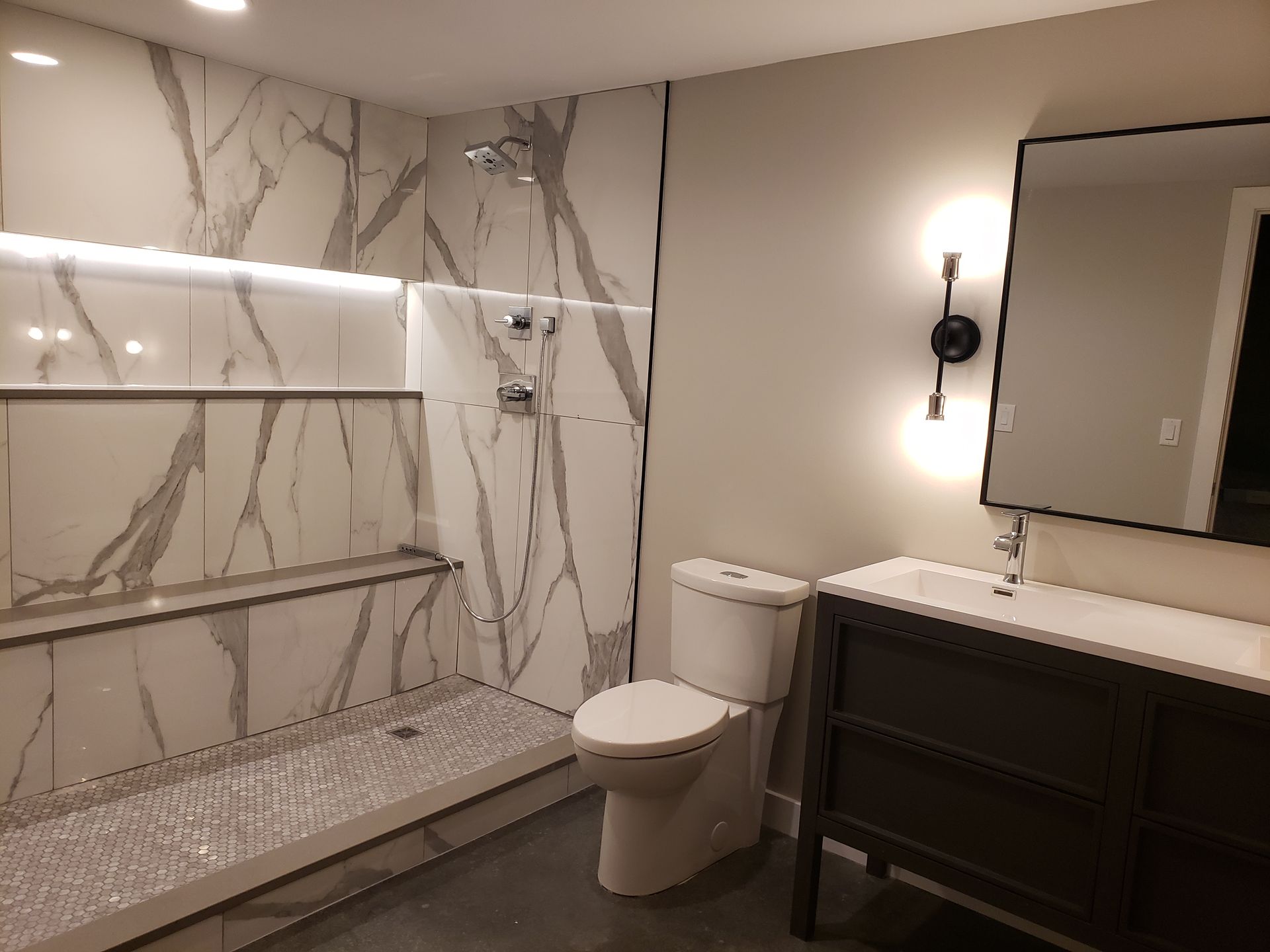 A bathroom with a toilet , sink and shower.