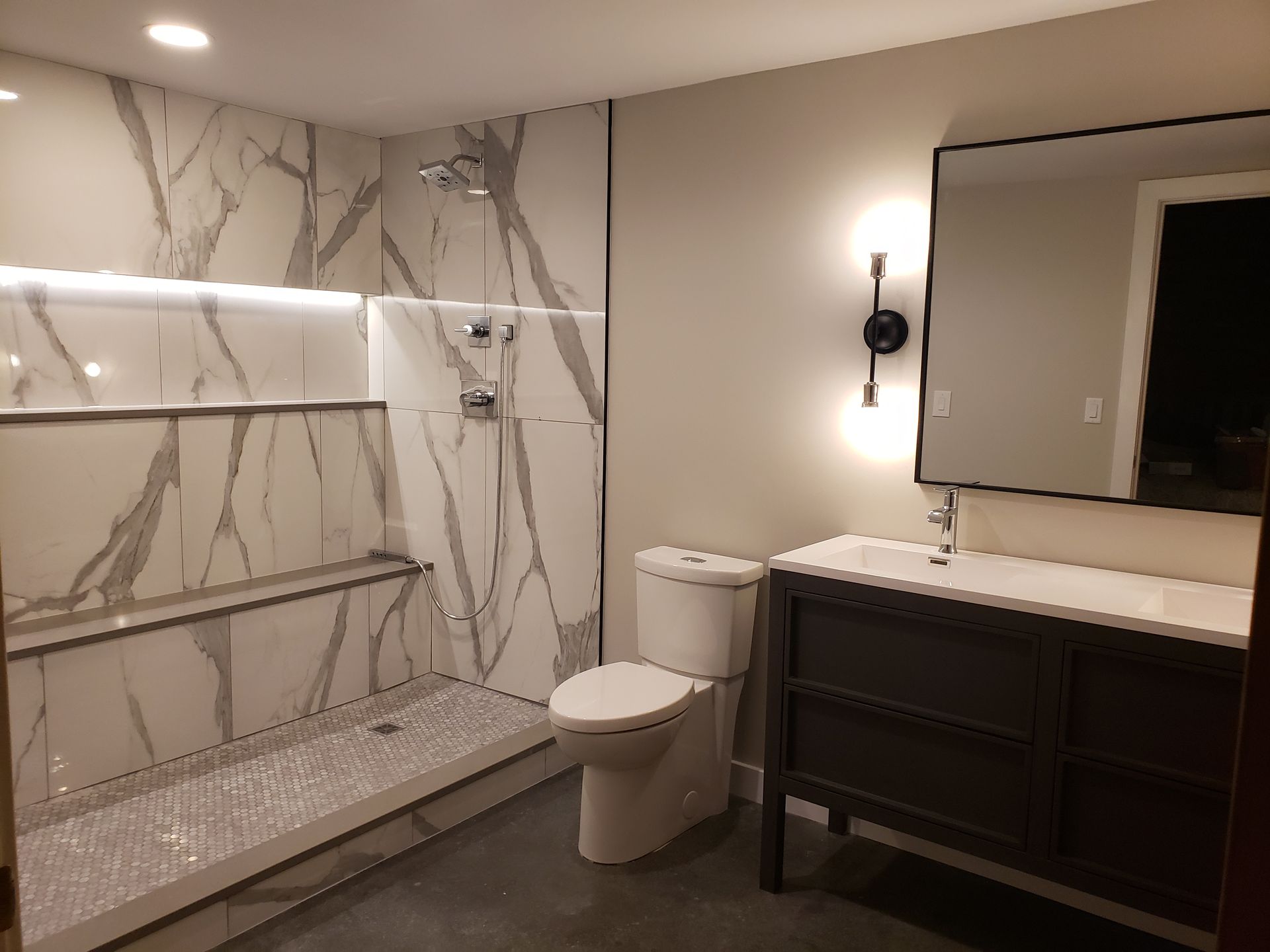 A bathroom with a toilet , sink and shower.