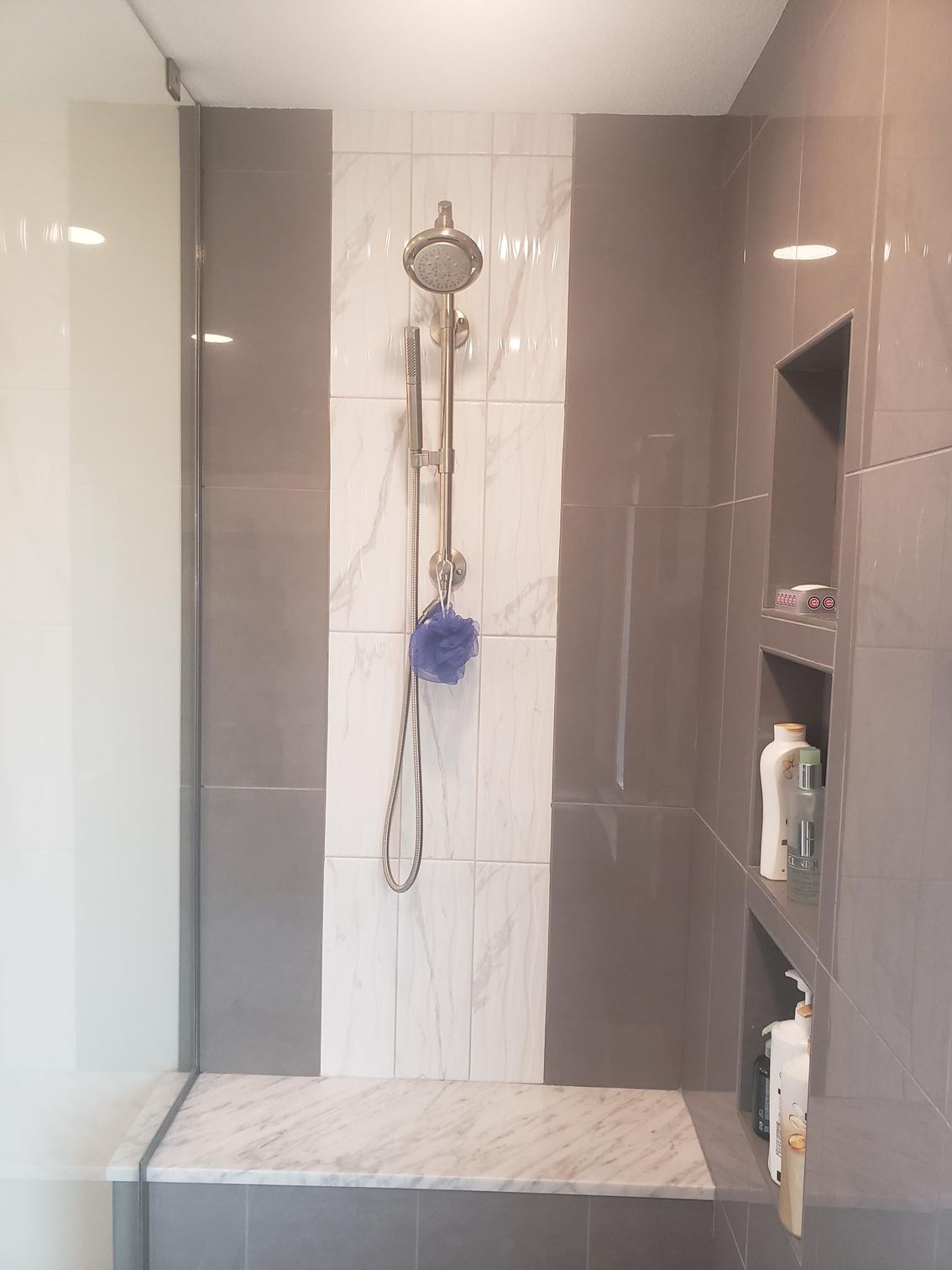 A bathroom with a walk in shower and a sponge in it.