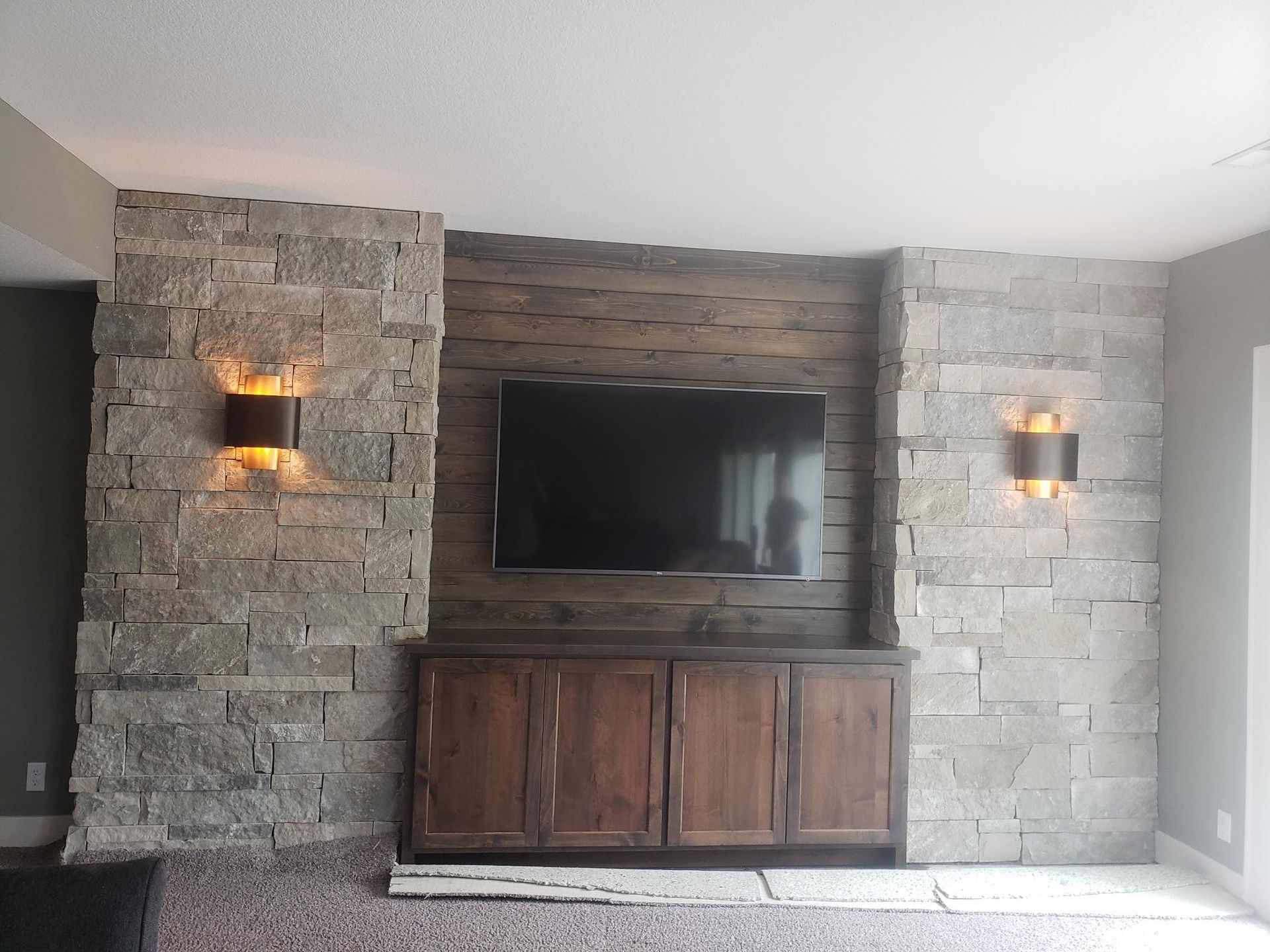 A living room with a brick wall and a flat screen tv