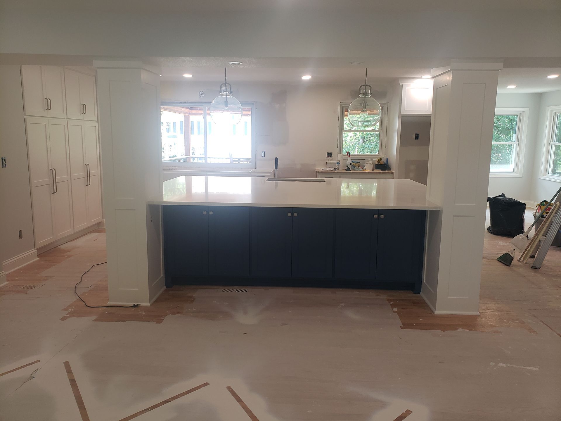 A kitchen with blue cabinets and white counter tops is being remodeled.
