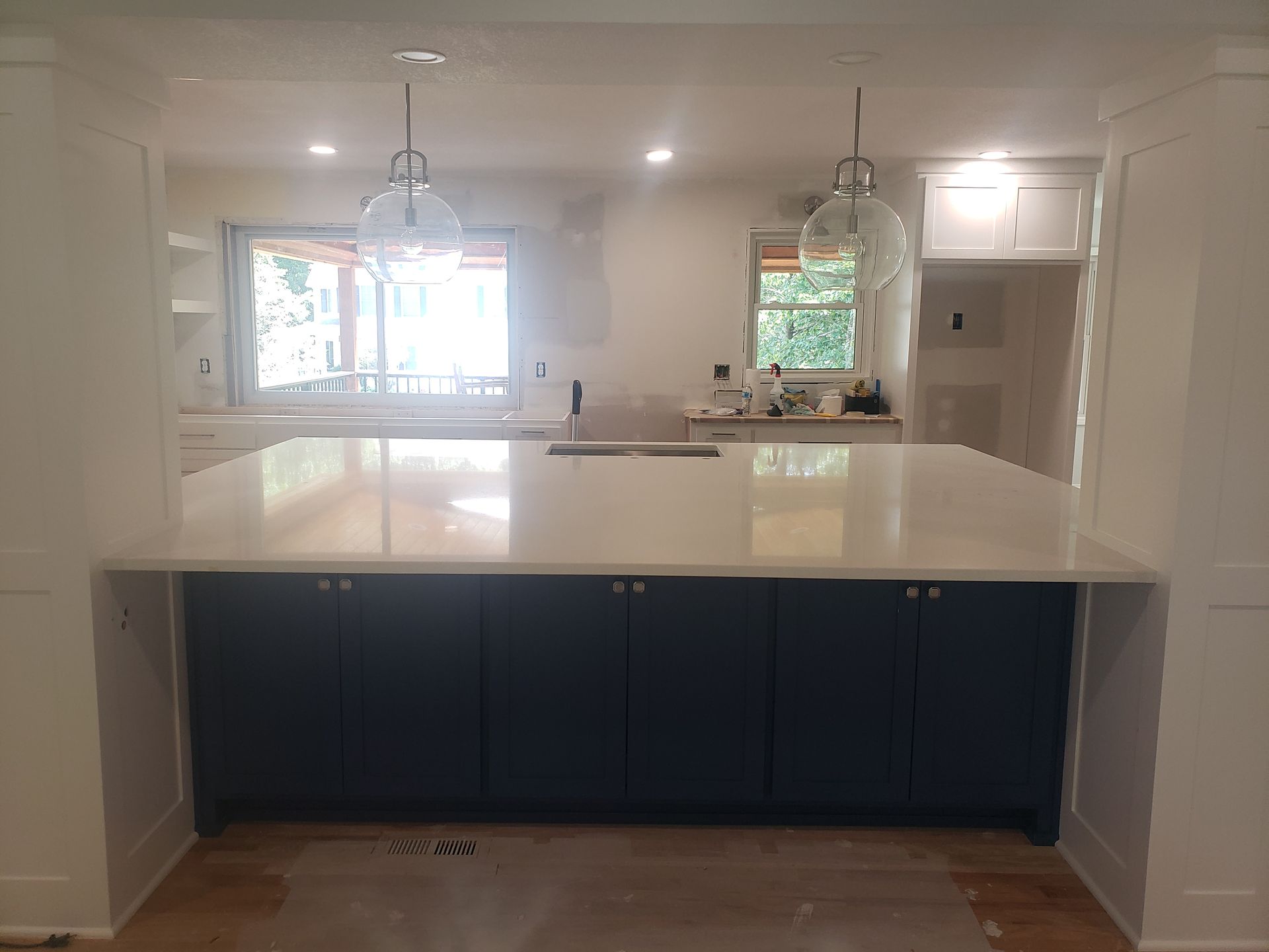 A kitchen with blue cabinets and white counter tops is being remodeled.