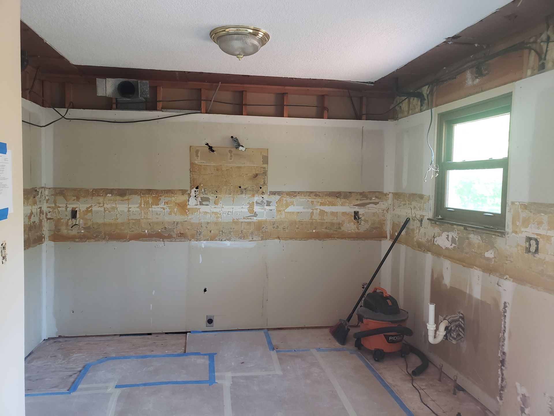 A room with a vacuum cleaner and a mop in it