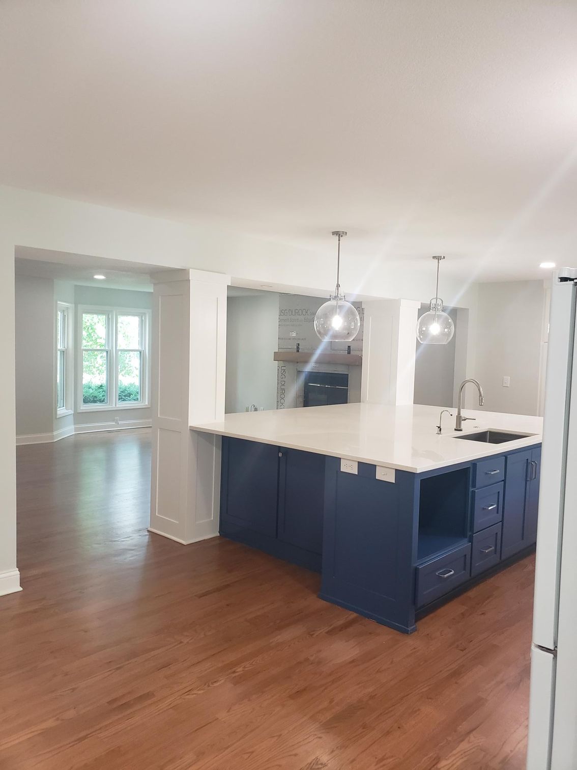 A kitchen with blue cabinets and white counter tops